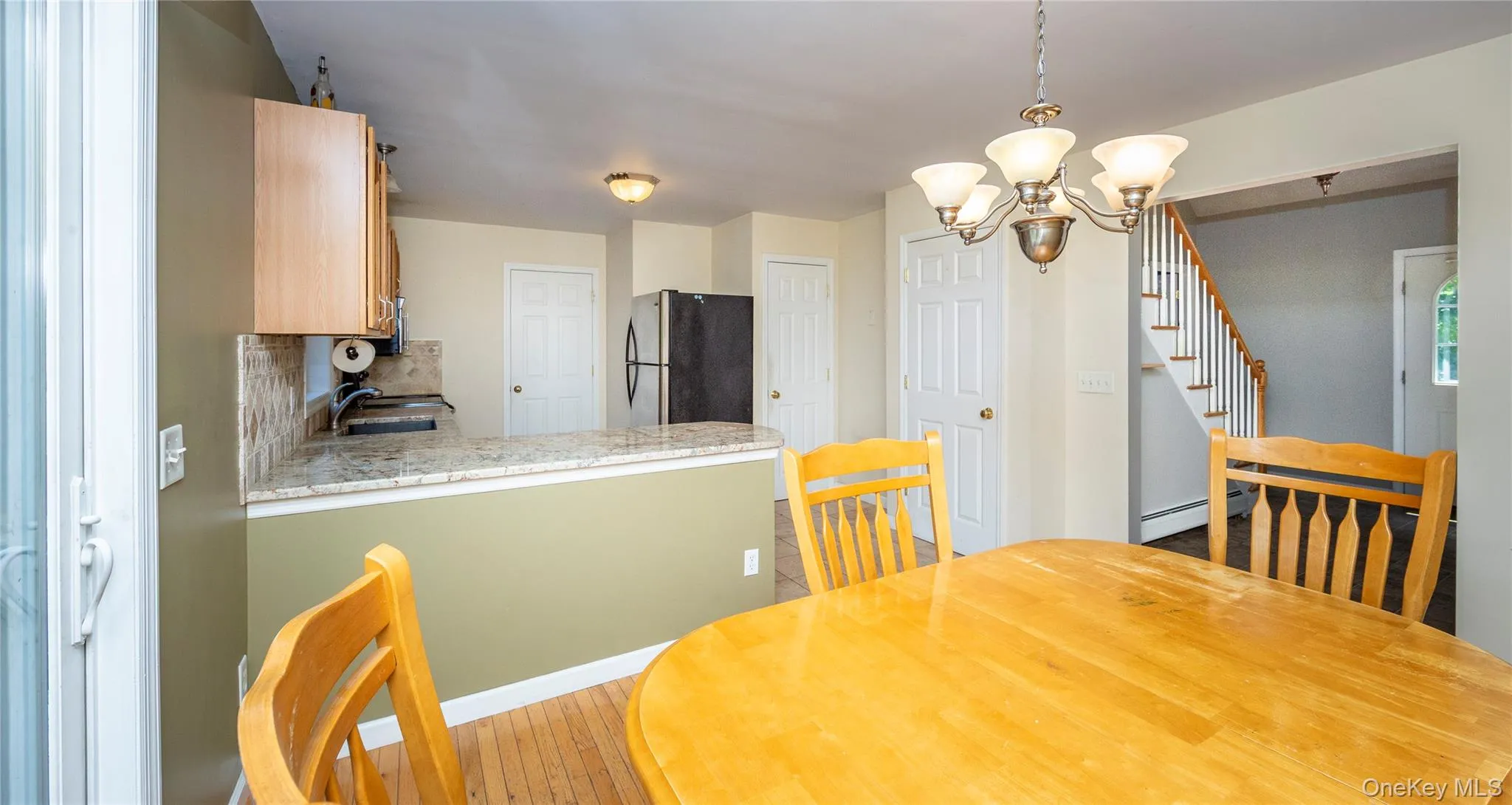 View from dining area to kitchen and entry area. View from dining area to kitchen and entry area.