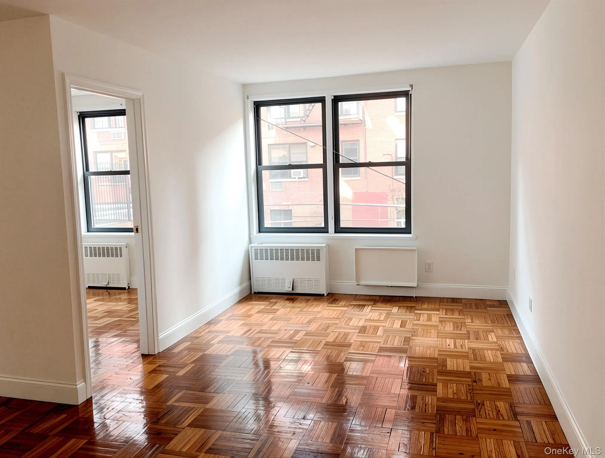 Parquet wood-finish flooring, white painted walls, and white baseboards Parquet wood-finish flooring, white painted walls, and white baseboards