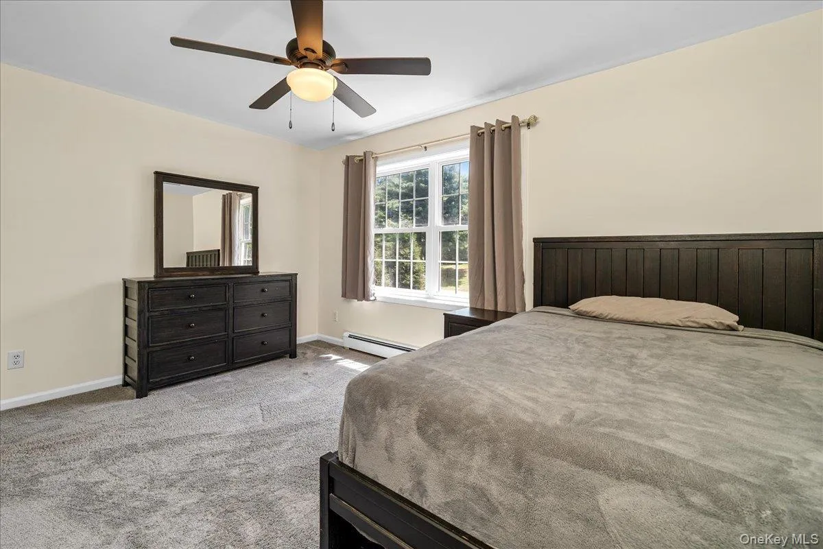 Carpeted room featuring a ceiling fan with integrated lighting, a double-hung window, and neutral wall tones. Carpeted room featuring a ceiling fan with integrated lighting, a double-hung window, and neutral wall tones.