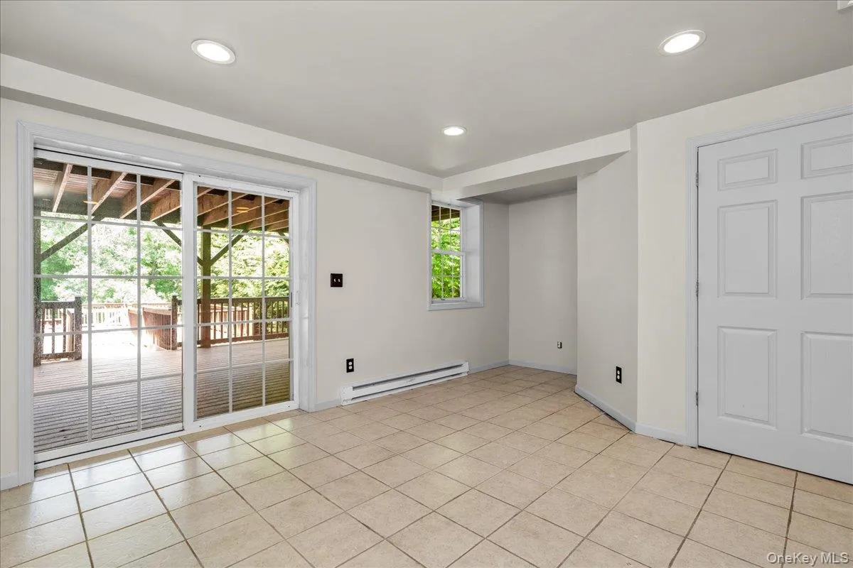 Basement with light-toned tiled flooring and recessed ceiling lighting. Sliding doors to back yard Basement with light-toned tiled flooring and recessed ceiling lighting. Sliding doors to back yard