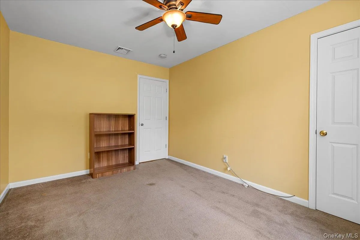 Carpeted bedroom with a ceiling fan light fixture, double-hung window, and baseboard heating Carpeted bedroom with a ceiling fan light fixture, double-hung window, and baseboard heating