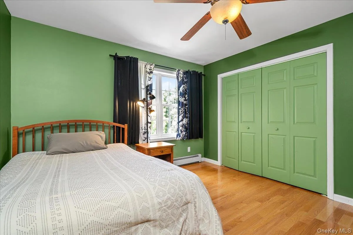 bedroom featuring light wood-finish flooring, a ceiling fan with integrated lighting, and a window with white trim bedroom featuring light wood-finish flooring, a ceiling fan with integrated lighting, and a window with white trim
