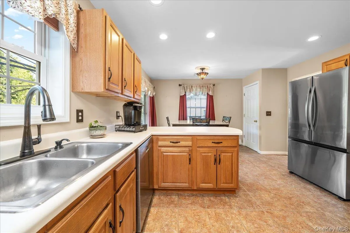 Kitchen featuring wood-finish cabinetry, a stainless steel double basin sink, and recessed lighting. Kitchen featuring wood-finish cabinetry, a stainless steel double basin sink, and recessed lighting.