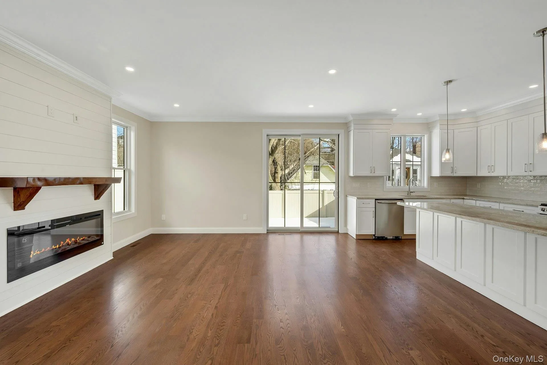 A view of the living room showing sliding glass doors out to yard and fireplace A view of the living room showing sliding glass doors out to yard and fireplace
