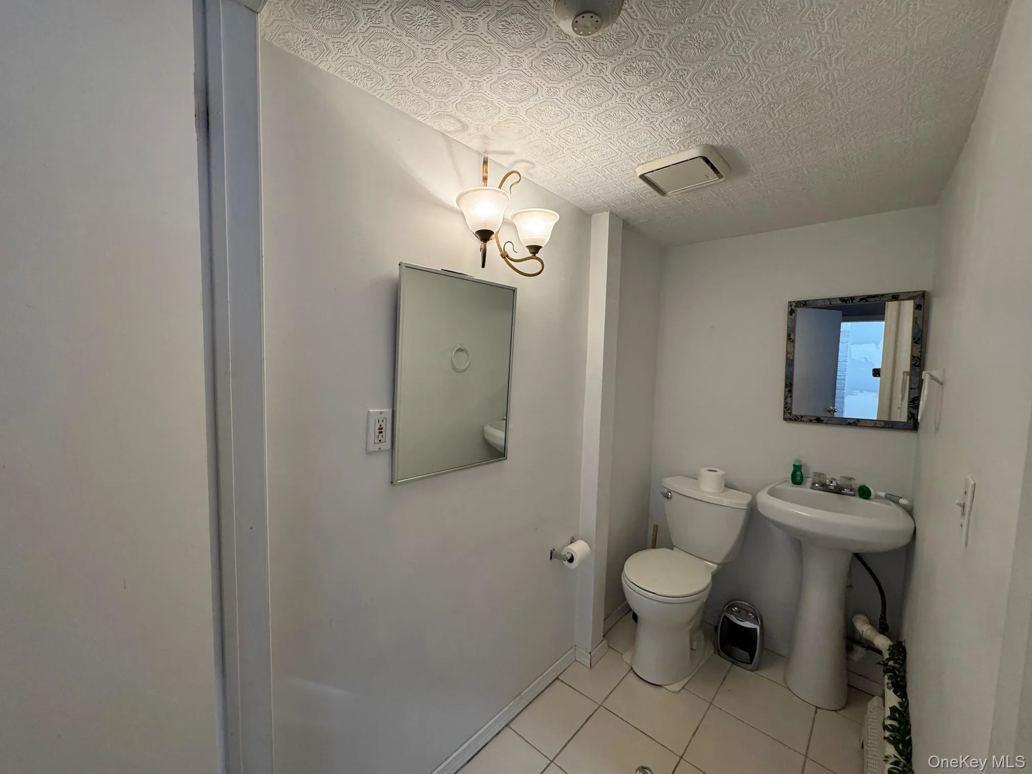 Bathroom featuring tile patterned flooring, toilet, and sink Bathroom featuring tile patterned flooring, toilet, and sink