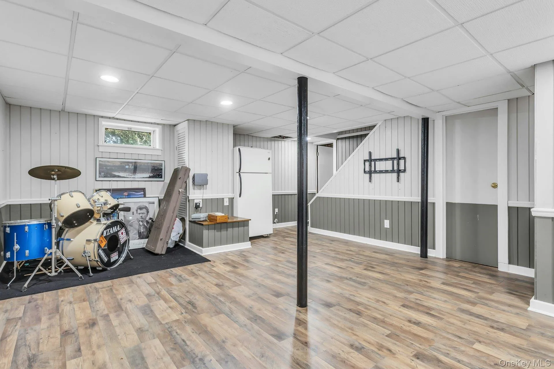 Spacious finished basement featuring wood-finish flooring, recessed lighting, and a drop ceiling Spacious finished basement featuring wood-finish flooring, recessed lighting, and a drop ceiling