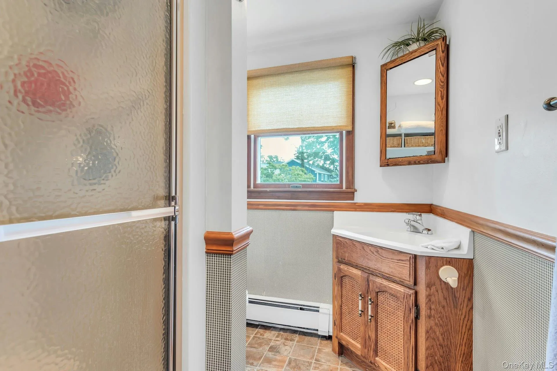 Bathroom featuring a corner vanity with a white countertop and integrated sink Bathroom featuring a corner vanity with a white countertop and integrated sink