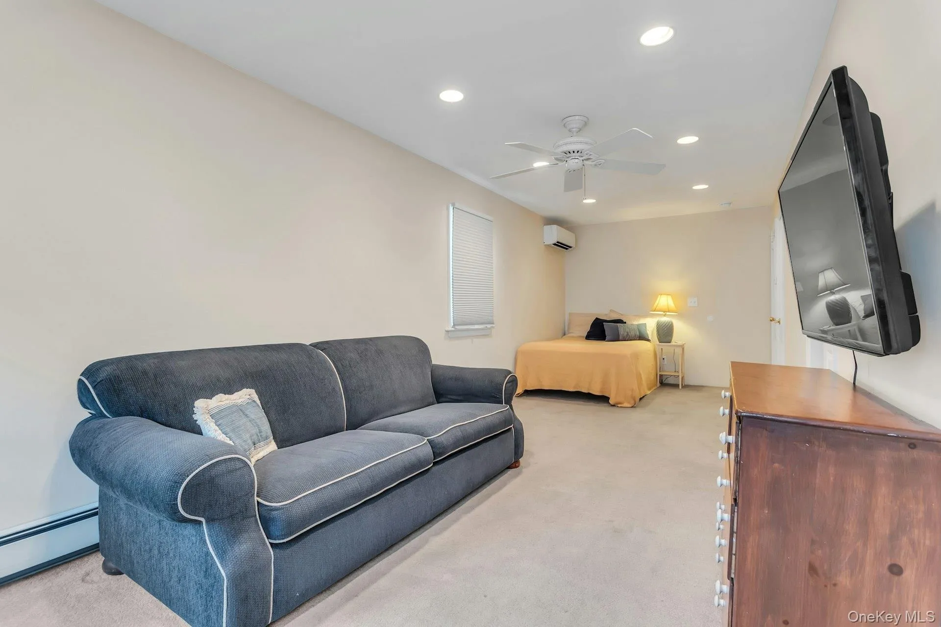 Carpeted living space featuring recessed lighting, a ceiling fan, and window treatments Carpeted living space featuring recessed lighting, a ceiling fan, and window treatments