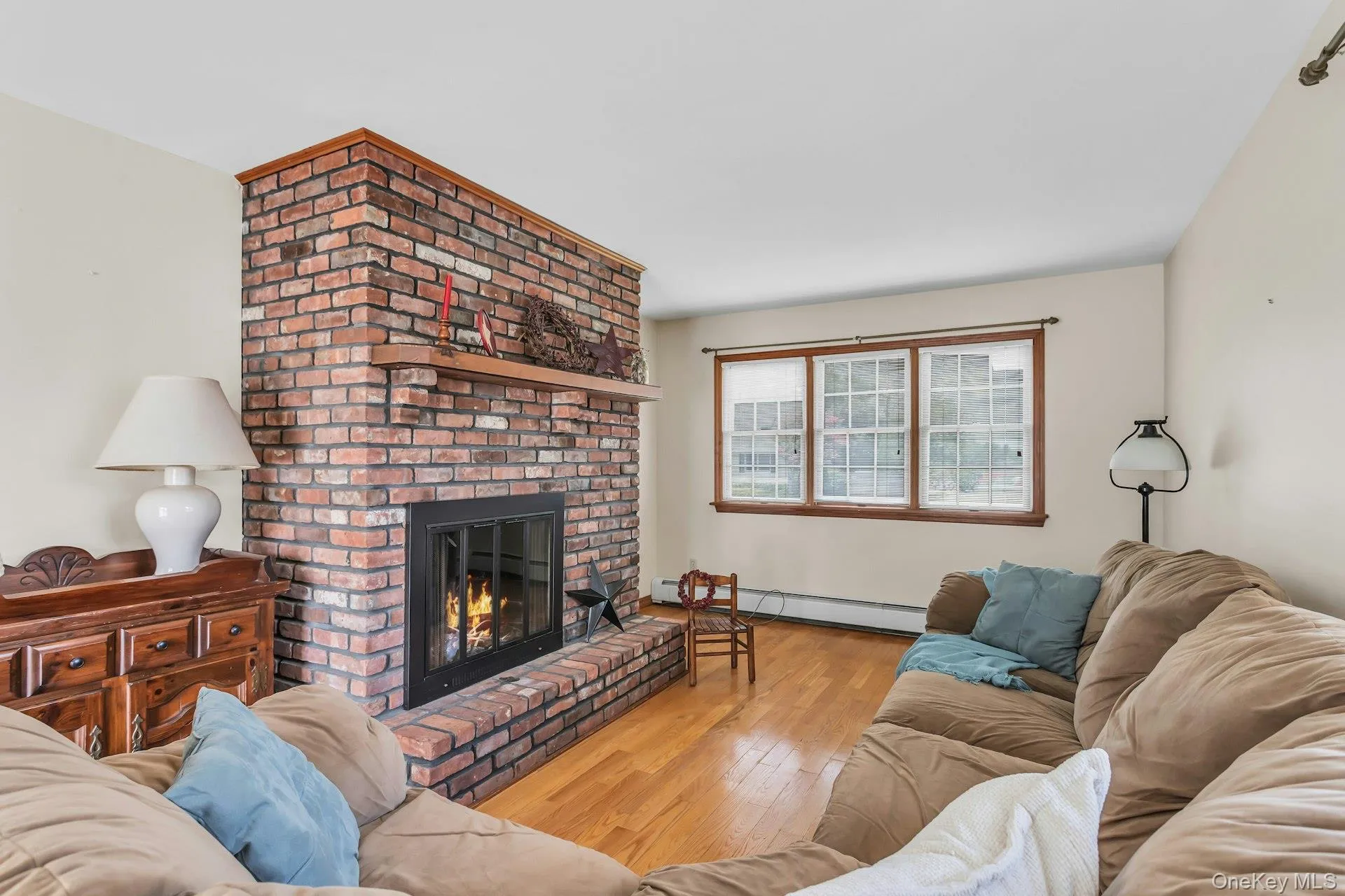 Brick fireplace with a wood mantel and glass-front insert Brick fireplace with a wood mantel and glass-front insert