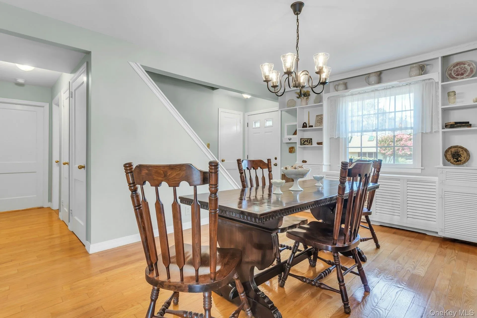 Hardwood flooring complements a built-in shelving unit with lower louvered cabinets Hardwood flooring complements a built-in shelving unit with lower louvered cabinets