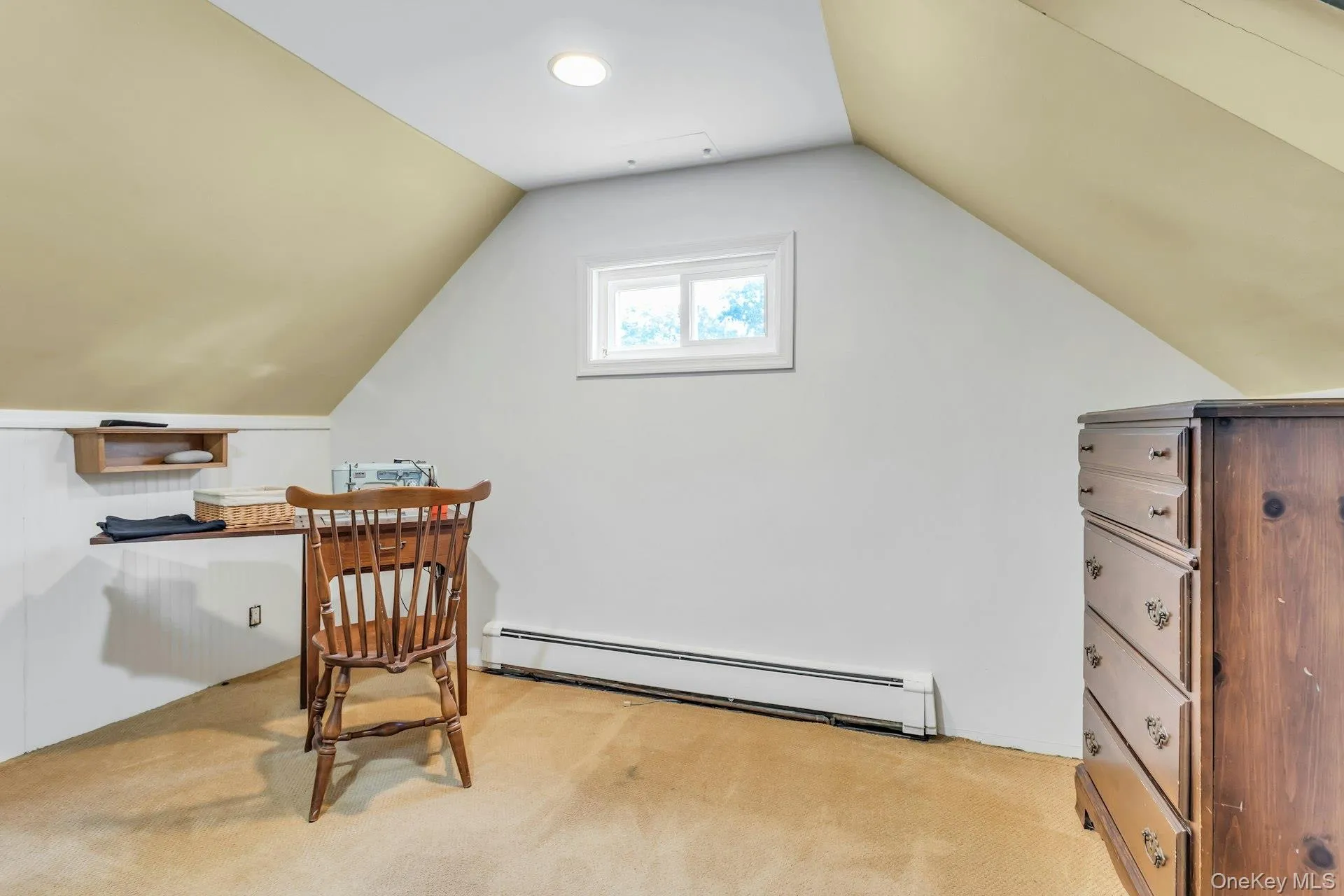 Attic space featuring a rectangular window, recessed lighting, baseboard heating, and sloped ceilings Attic space featuring a rectangular window, recessed lighting, baseboard heating, and sloped ceilings