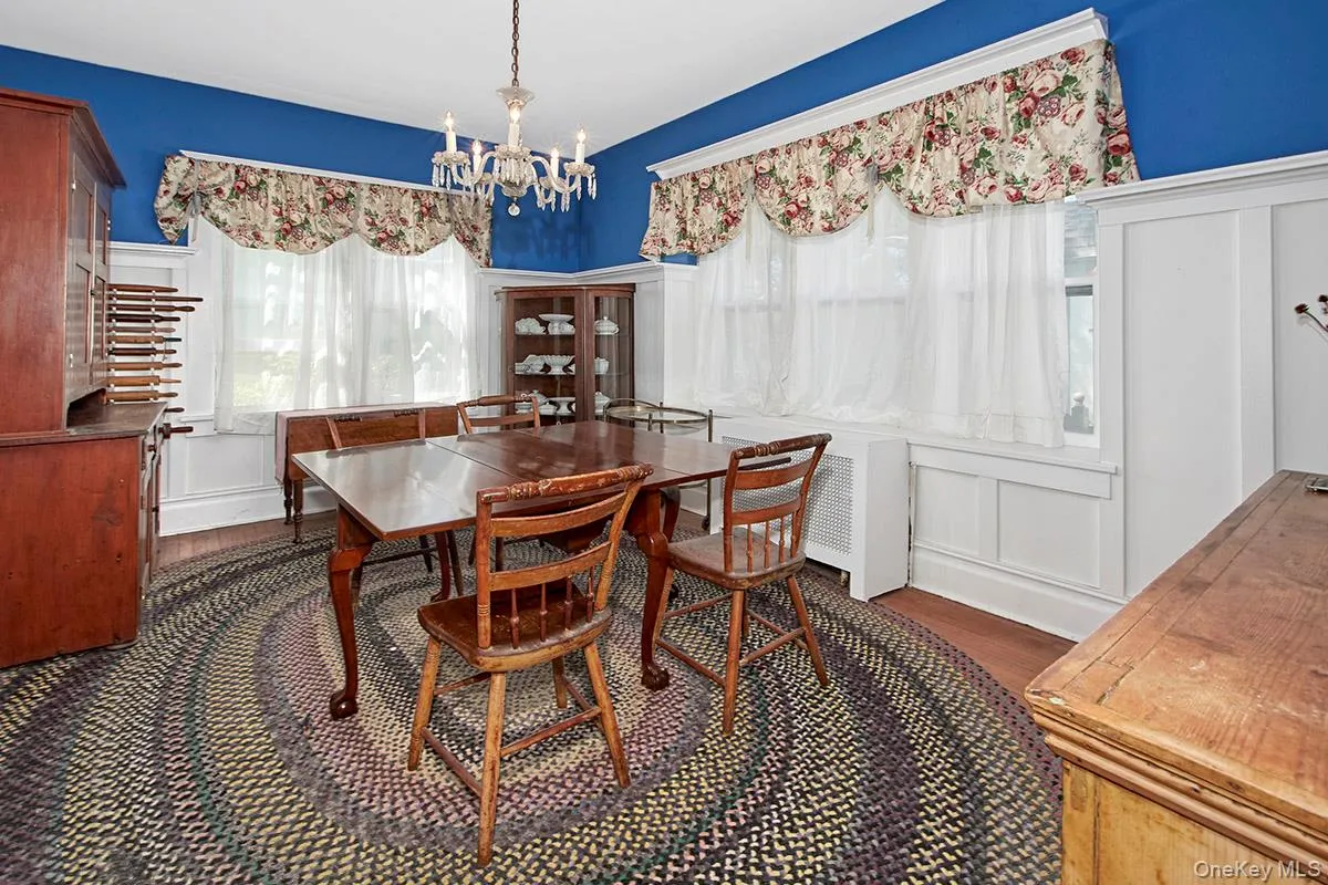 Dining room featuring hardwood flooring, a chandelier light fixture, and extensive white trim details Dining room featuring hardwood flooring, a chandelier light fixture, and extensive white trim details