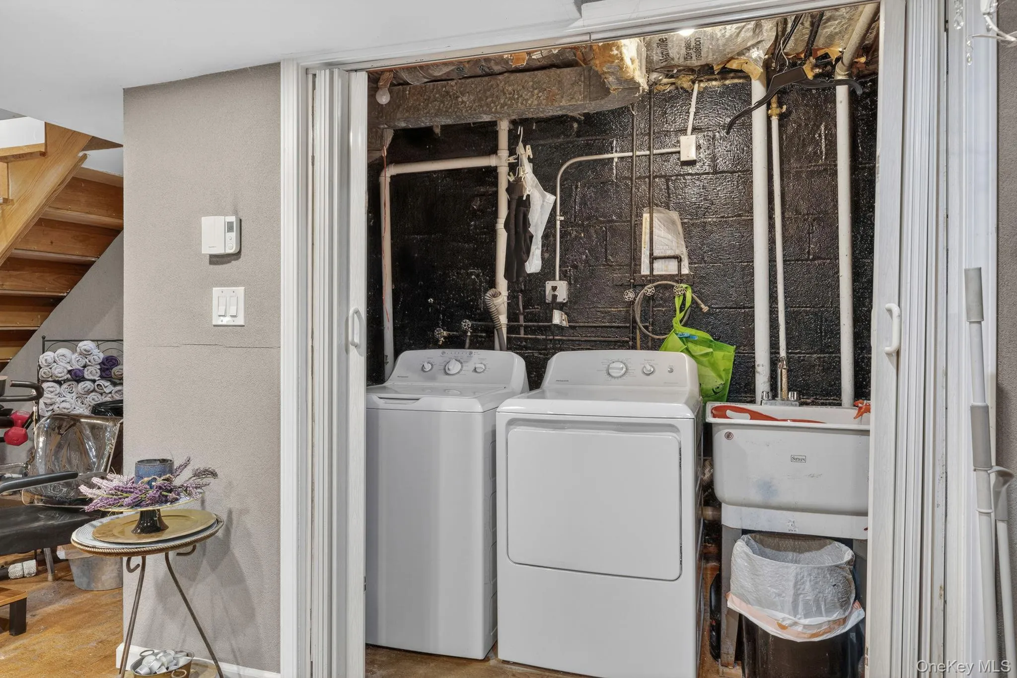 Dedicated laundry area with a top-load washing machine, front-load dryer, and utility sink Dedicated laundry area with a top-load washing machine, front-load dryer, and utility sink