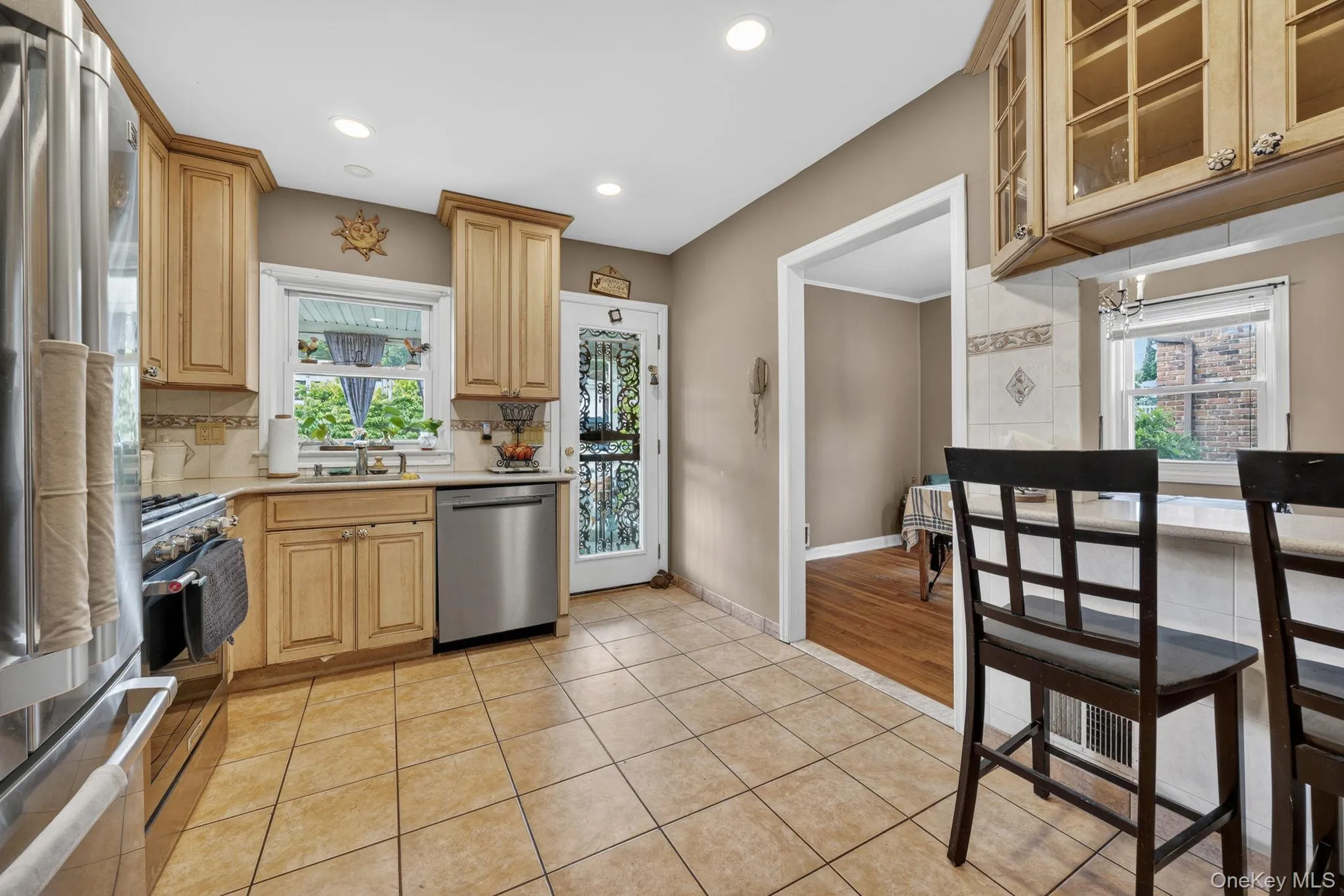 Kitchen with tile flooring, stainless steel appliances, light wood-finish cabinetry, recessed lighting, and a window above the sink Kitchen with tile flooring, stainless steel appliances, light wood-finish cabinetry, recessed lighting, and a window above the sink