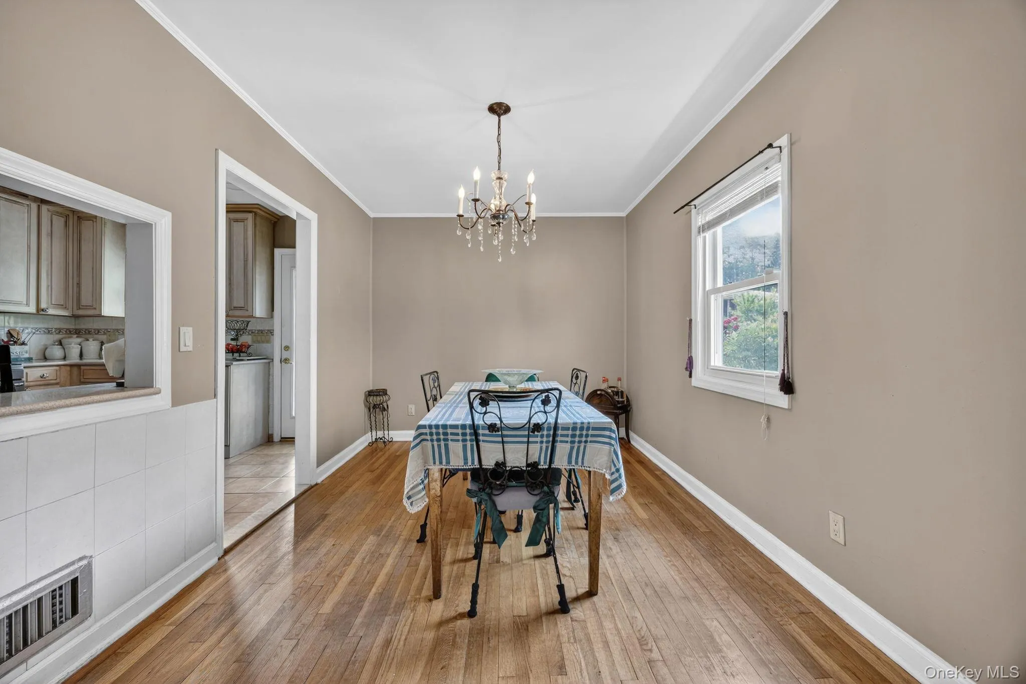 Dining area featuring wood-finish flooring, a chandelier light fixture, and a window with natural light Dining area featuring wood-finish flooring, a chandelier light fixture, and a window with natural light