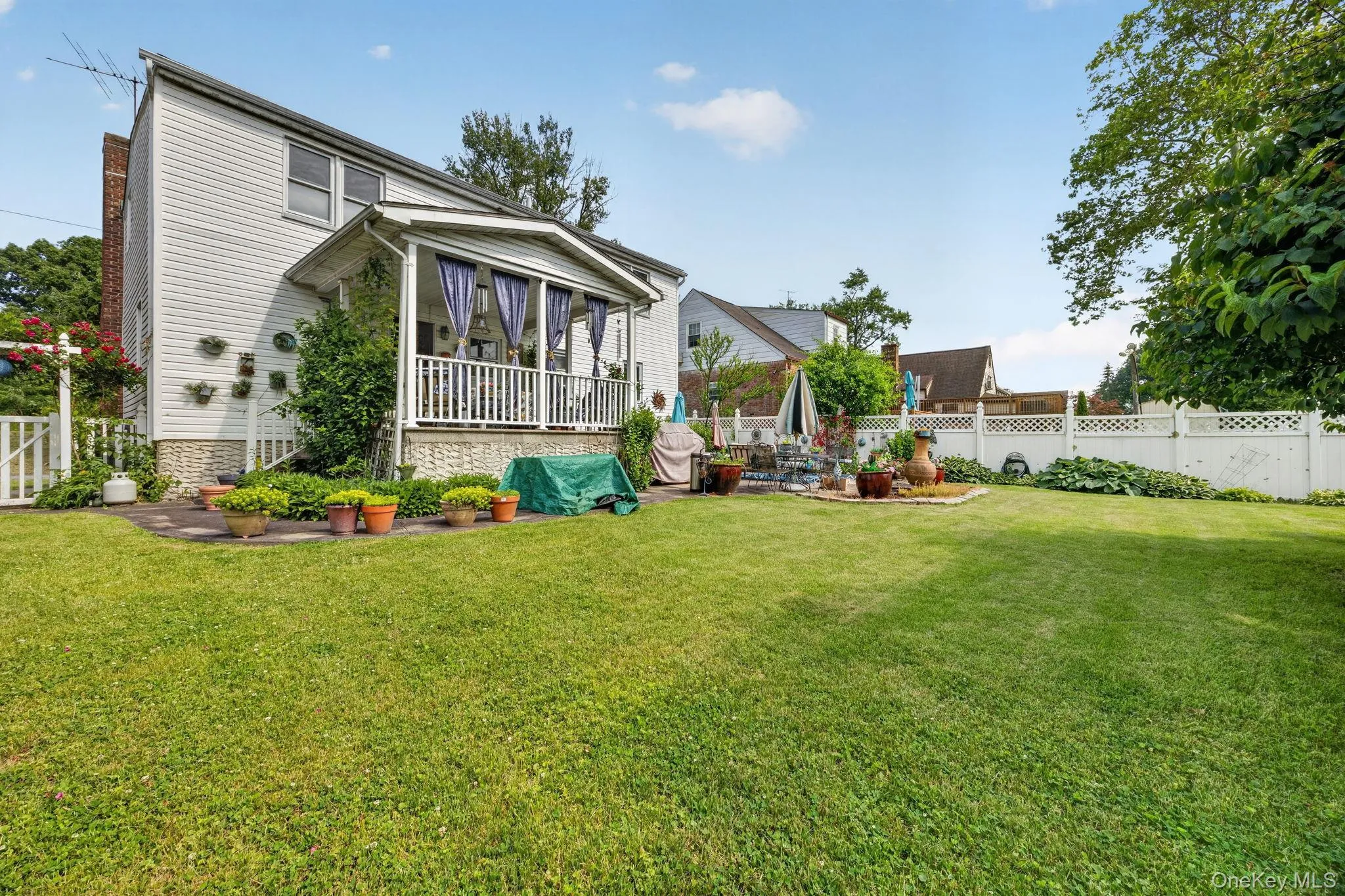 Spacious backyard featuring a manicured lawn and a privacy fence Spacious backyard featuring a manicured lawn and a privacy fence