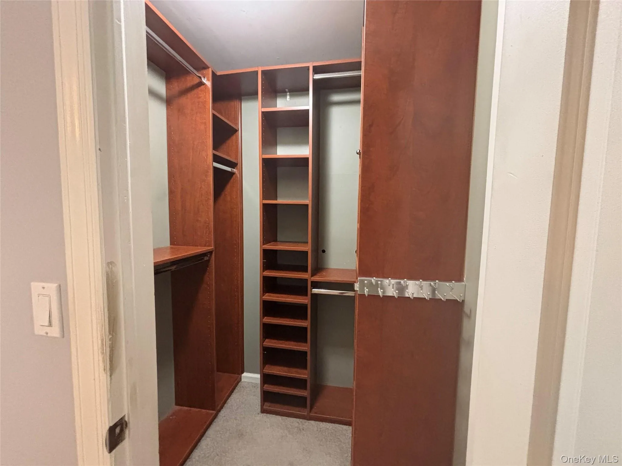 Custom closet system featuring wood-finish shelving, multiple hanging rods, and an integrated shoe rack Custom closet system featuring wood-finish shelving, multiple hanging rods, and an integrated shoe rack