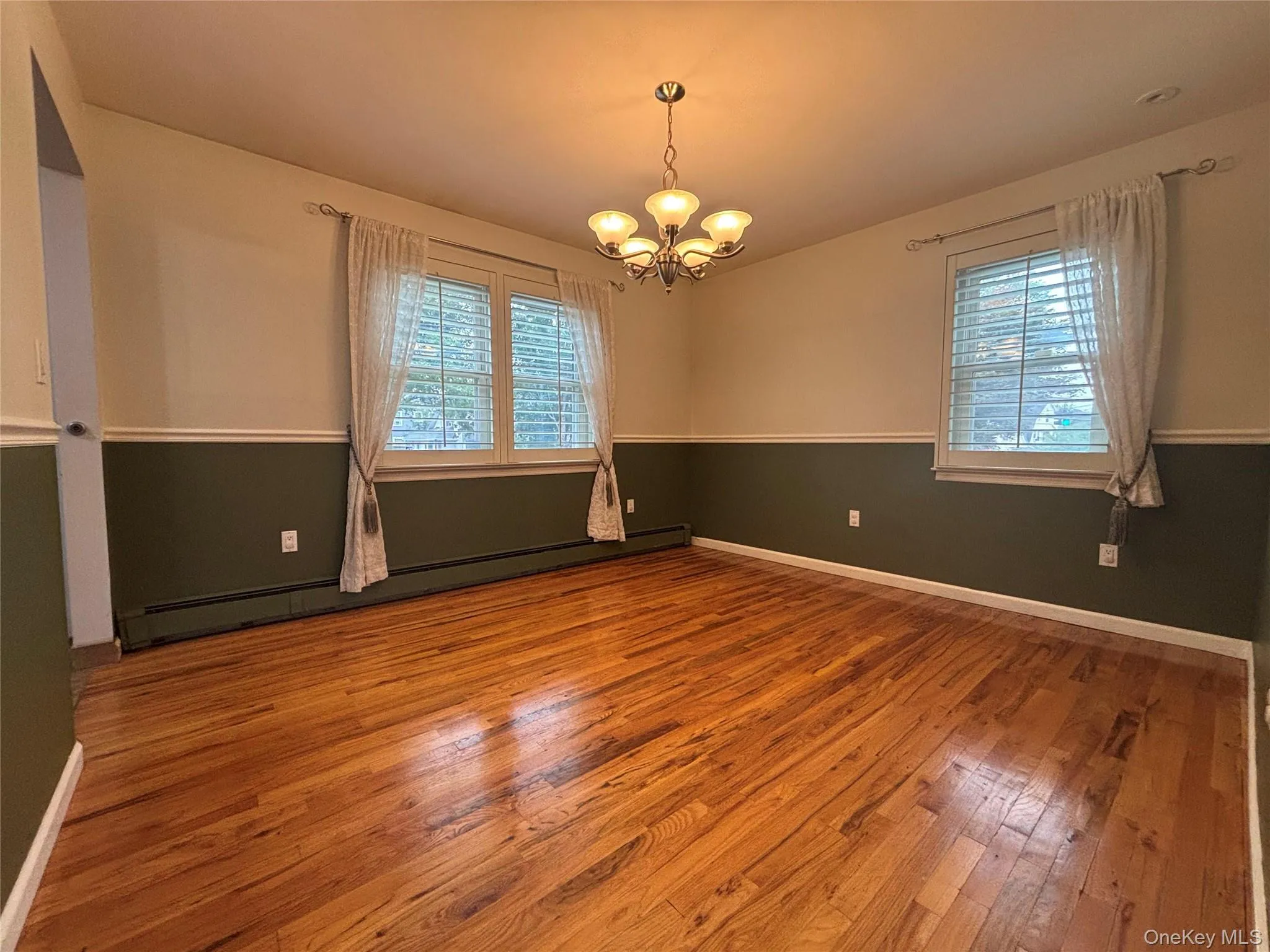 Hardwood flooring throughout featuring two-tone walls with white trim Hardwood flooring throughout featuring two-tone walls with white trim