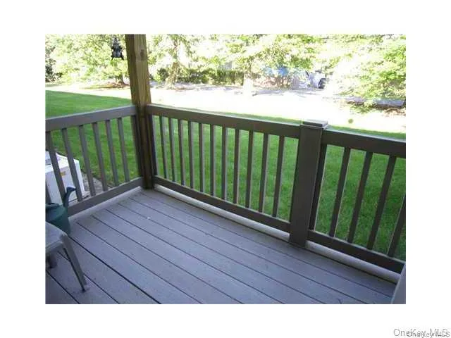 There's a private trex deck overlooking a grassy courtyard with trees There's a private trex deck overlooking a grassy courtyard with trees