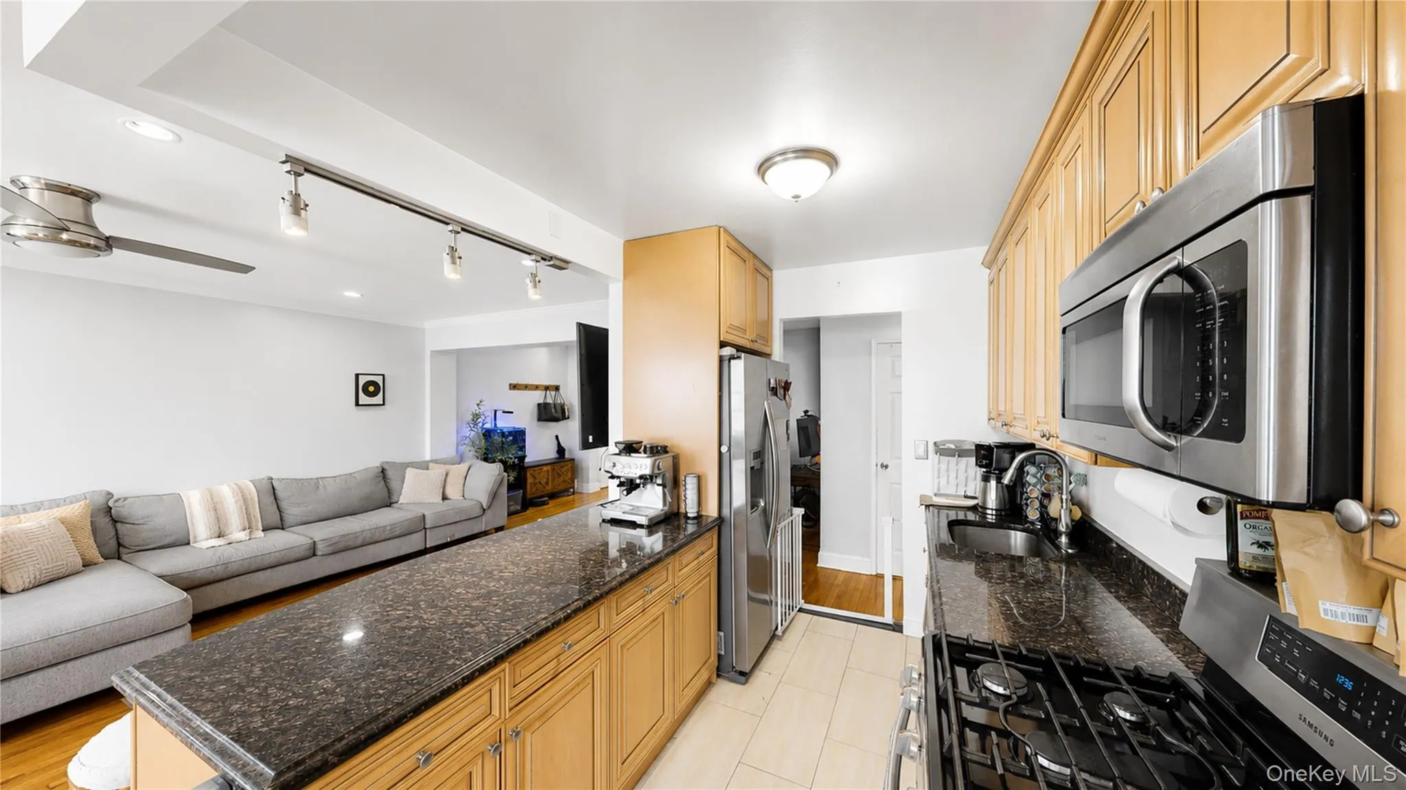 Well-appointed kitchen featuring light wood cabinetry, stone countertops, stainless steel appliances, and a gas range Well-appointed kitchen featuring light wood cabinetry, stone countertops, stainless steel appliances, and a gas range