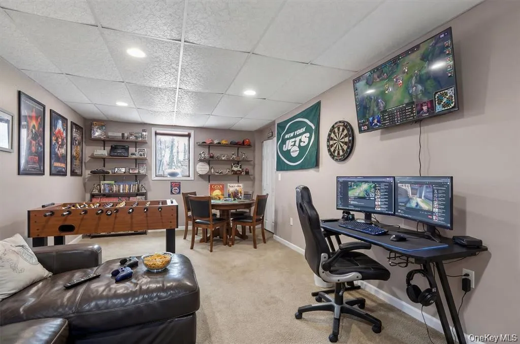Finished basement space featuring a drop ceiling with recessed lighting, with egress Finished basement space featuring a drop ceiling with recessed lighting, with egress