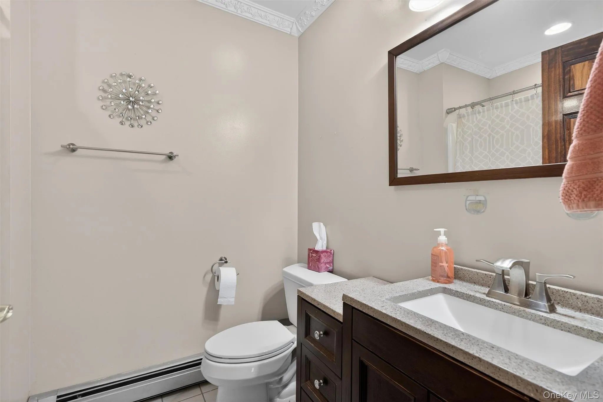 Bathroom featuring a wood-finish vanity with a light-toned countertop and integrated sink and Tub Bathroom featuring a wood-finish vanity with a light-toned countertop and integrated sink and Tub