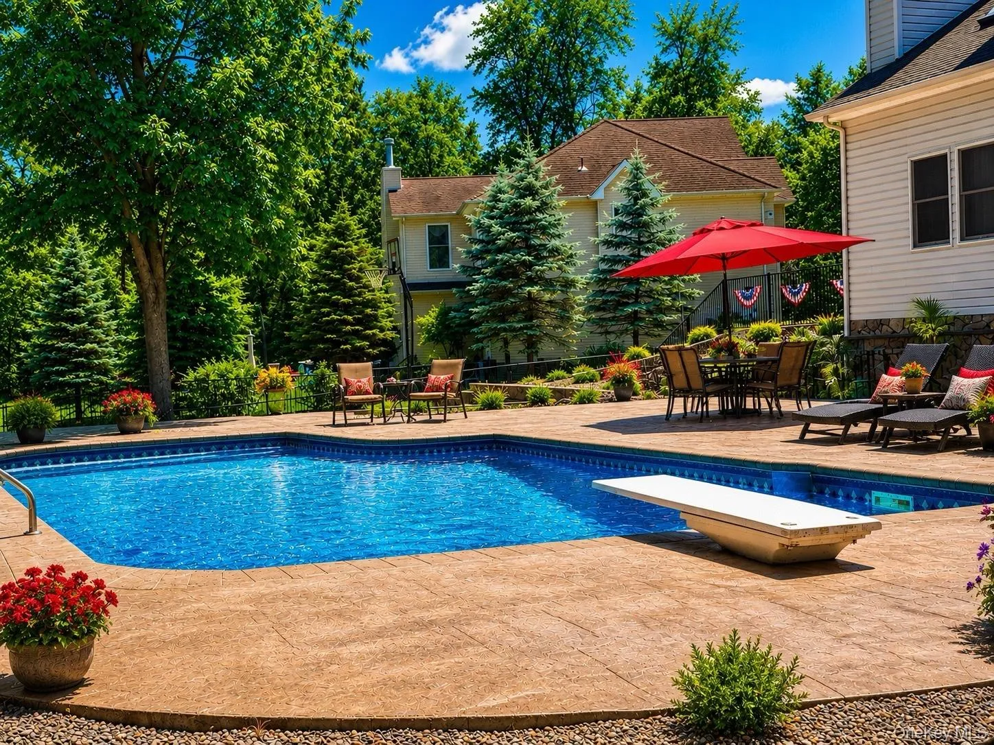 In-ground swimming pool with diving board, surrounded by stamped concrete decking In-ground swimming pool with diving board, surrounded by stamped concrete decking