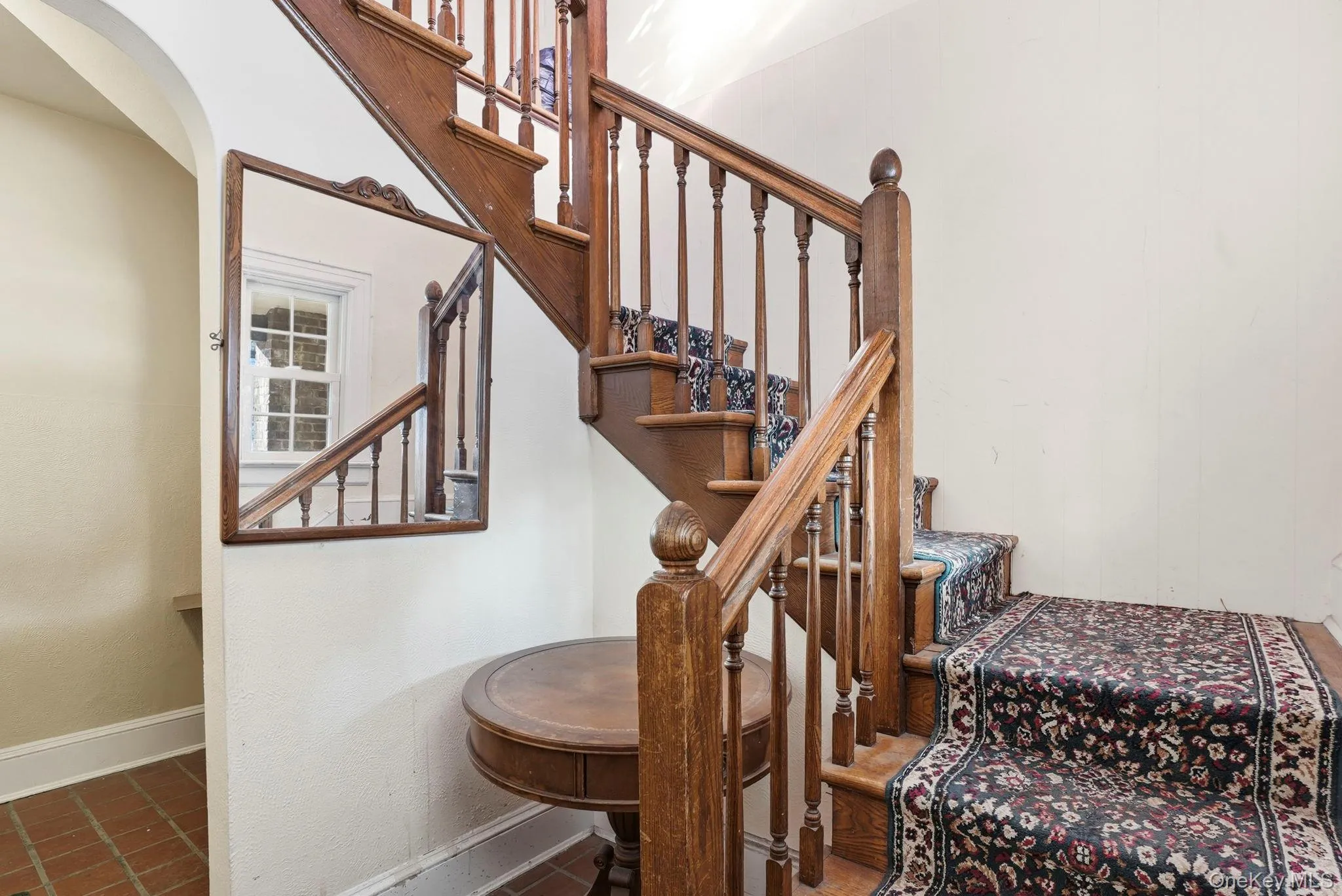 Solid wood staircase featuring a decorative runner, turned balusters, and a substantial newel post Solid wood staircase featuring a decorative runner, turned balusters, and a substantial newel post