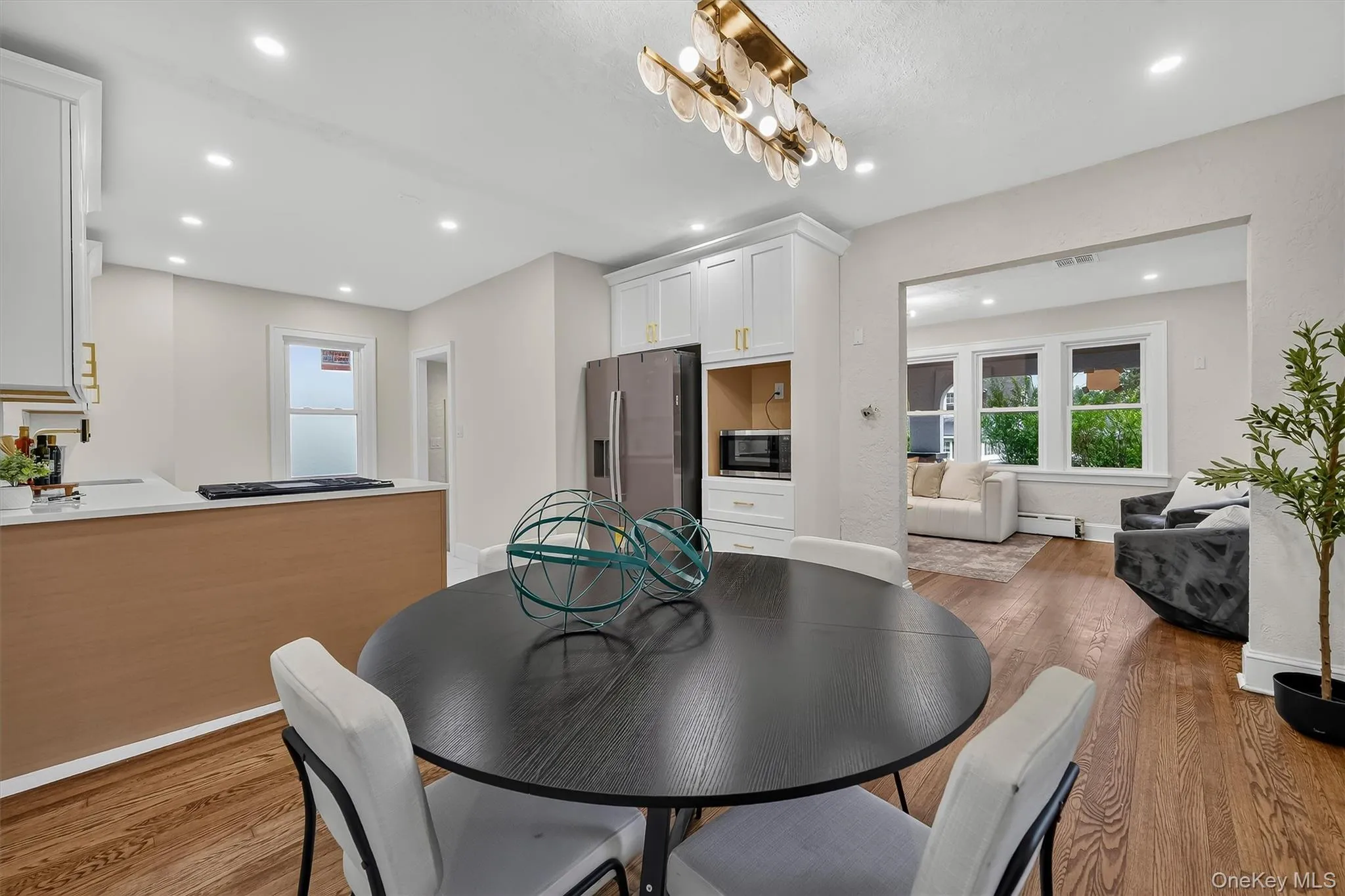 Open concept kitchen and dining area featuring recessed lighting and wood-finish flooring Open concept kitchen and dining area featuring recessed lighting and wood-finish flooring