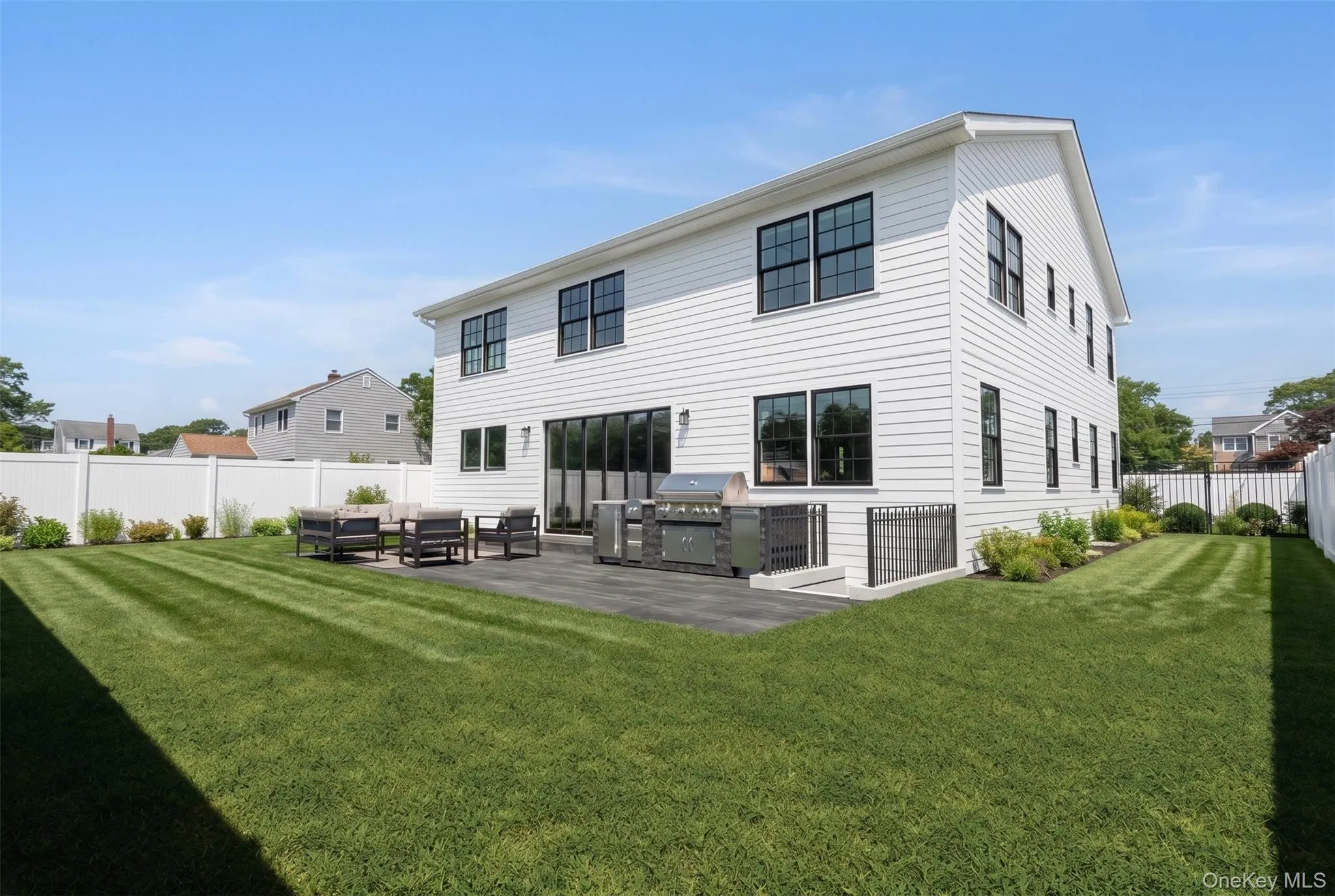 Rear exterior featuring white siding and black-framed windows Rear exterior featuring white siding and black-framed windows
