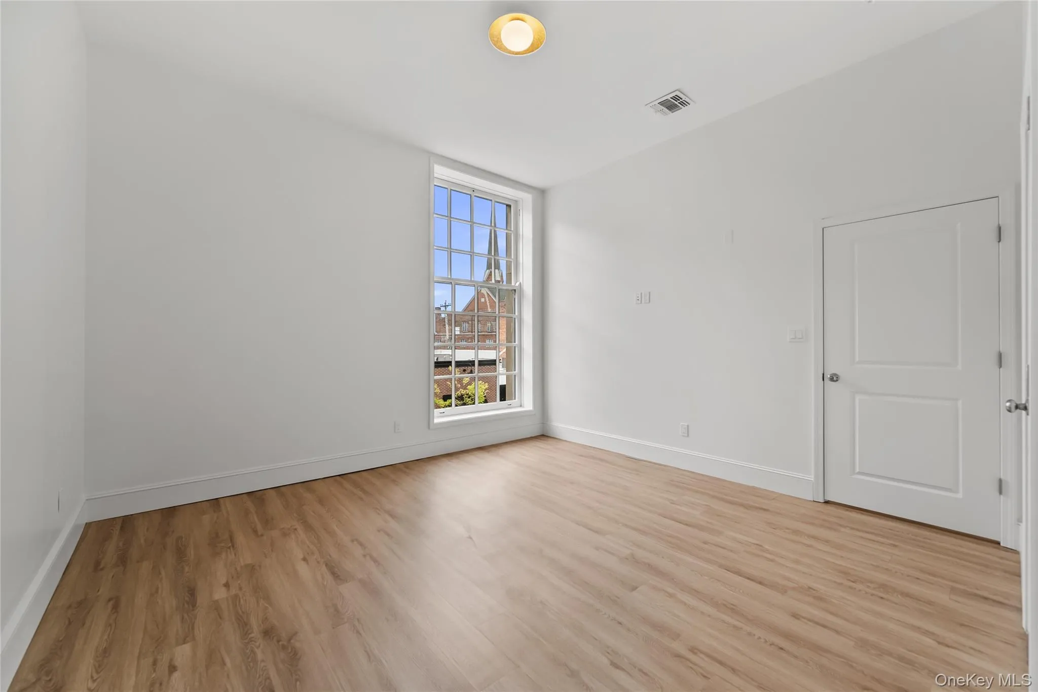 Primary Bedroom with high ceilings and large window Primary Bedroom with high ceilings and large window