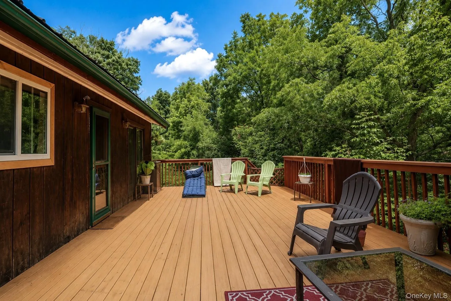 Expansive wood-finish deck with a full wood railing system, offering outdoor living space Expansive wood-finish deck with a full wood railing system, offering outdoor living space