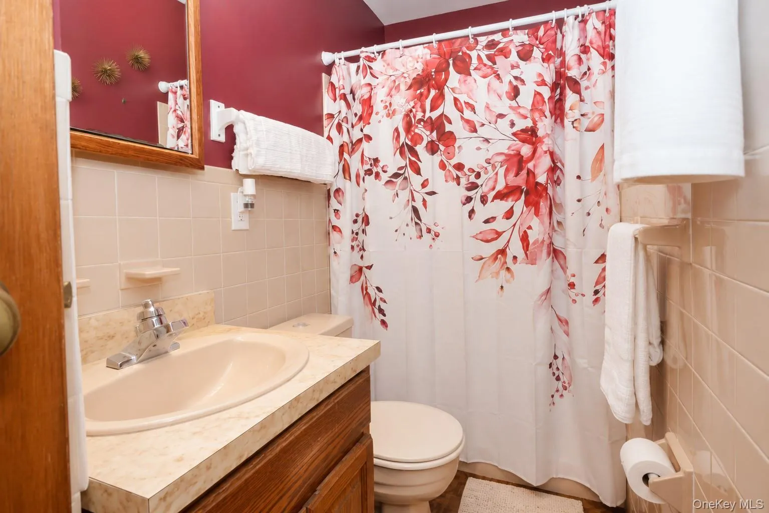 Bathroom featuring a wood-finish vanity with a built-in sink and speckled countertop Bathroom featuring a wood-finish vanity with a built-in sink and speckled countertop