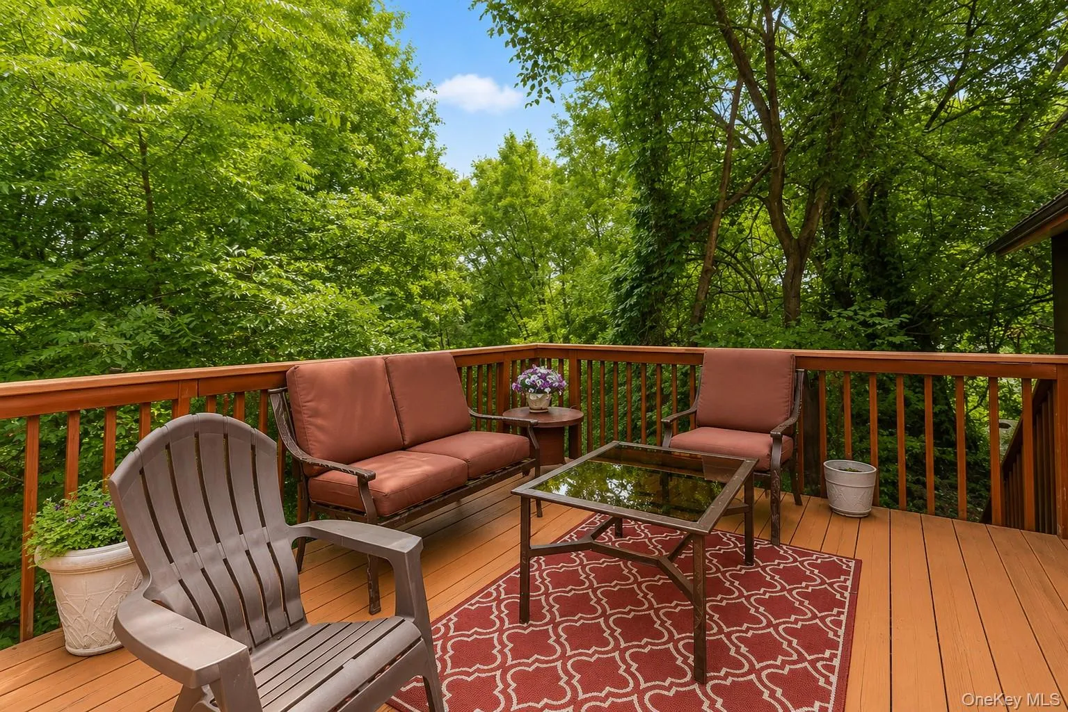 Expansive wood deck with a full wood railing system, offering an outdoor living space among mature trees Expansive wood deck with a full wood railing system, offering an outdoor living space among mature trees