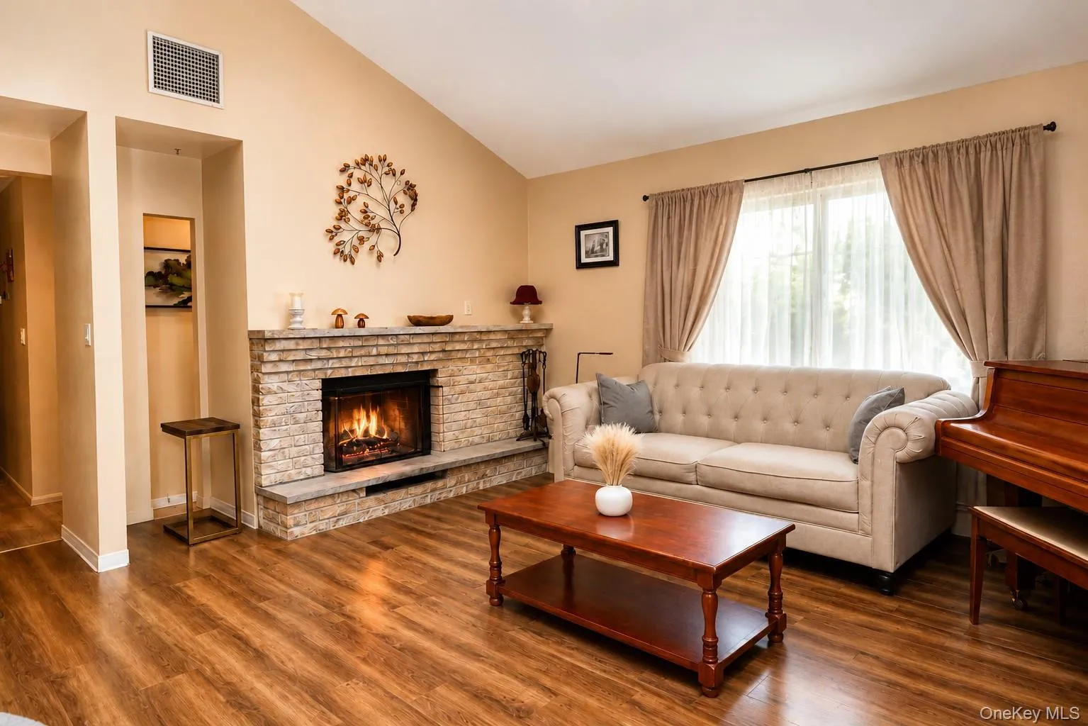 Spacious living area featuring a vaulted ceiling and wood-finish flooring FP is showing digital enhancement Spacious living area featuring a vaulted ceiling and wood-finish flooring FP is showing digital enhancement