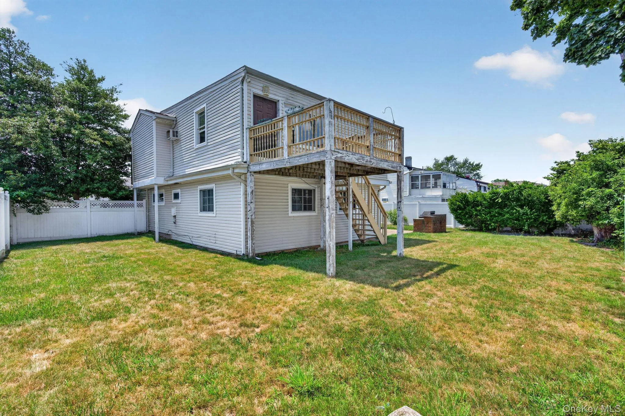 Spacious backyard featuring a multi-level structure with a second-story deck, exterior staircase, and vinyl siding Spacious backyard featuring a multi-level structure with a second-story deck, exterior staircase, and vinyl siding