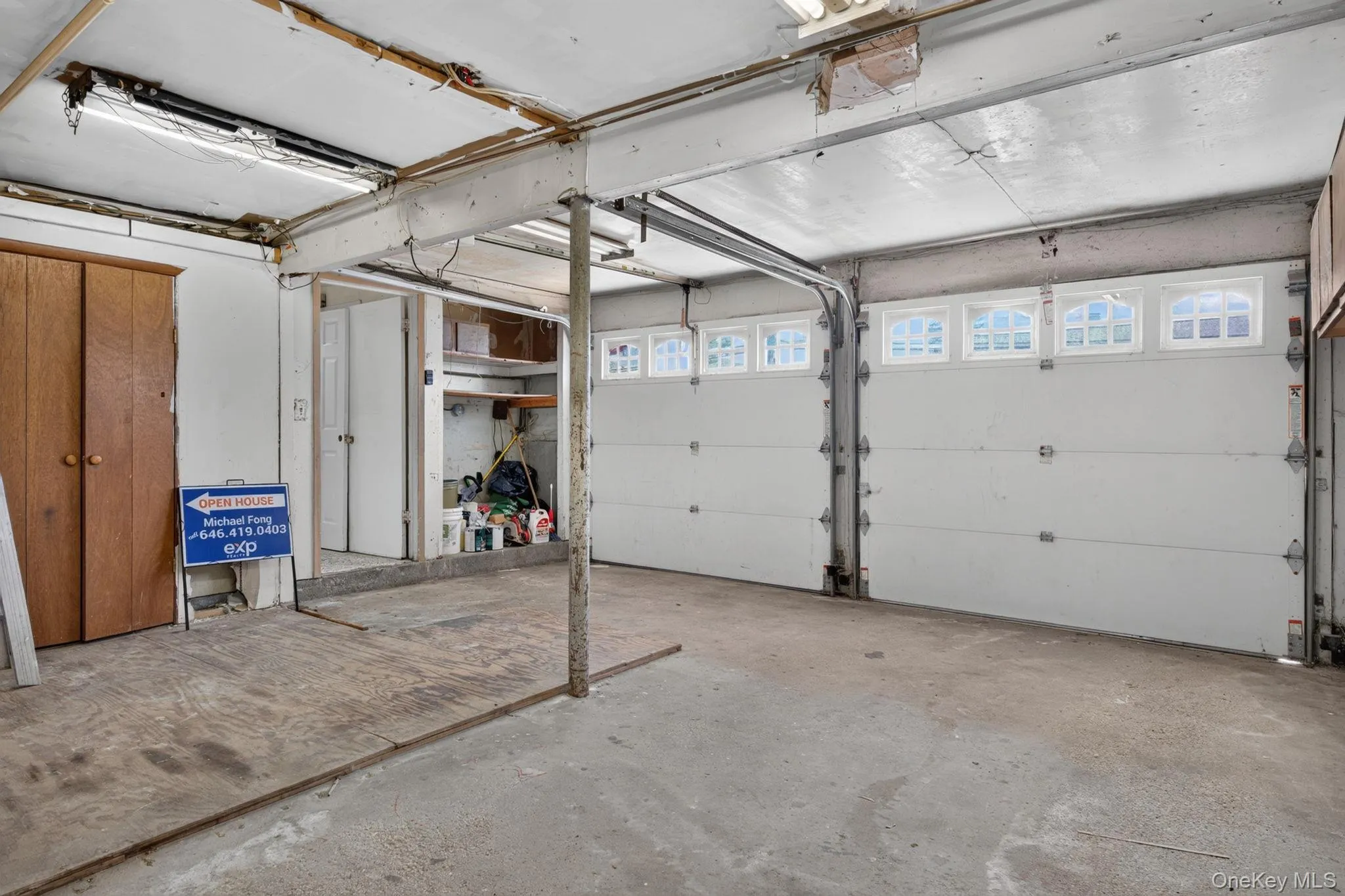 Two white garage doors with arched window panels Two white garage doors with arched window panels