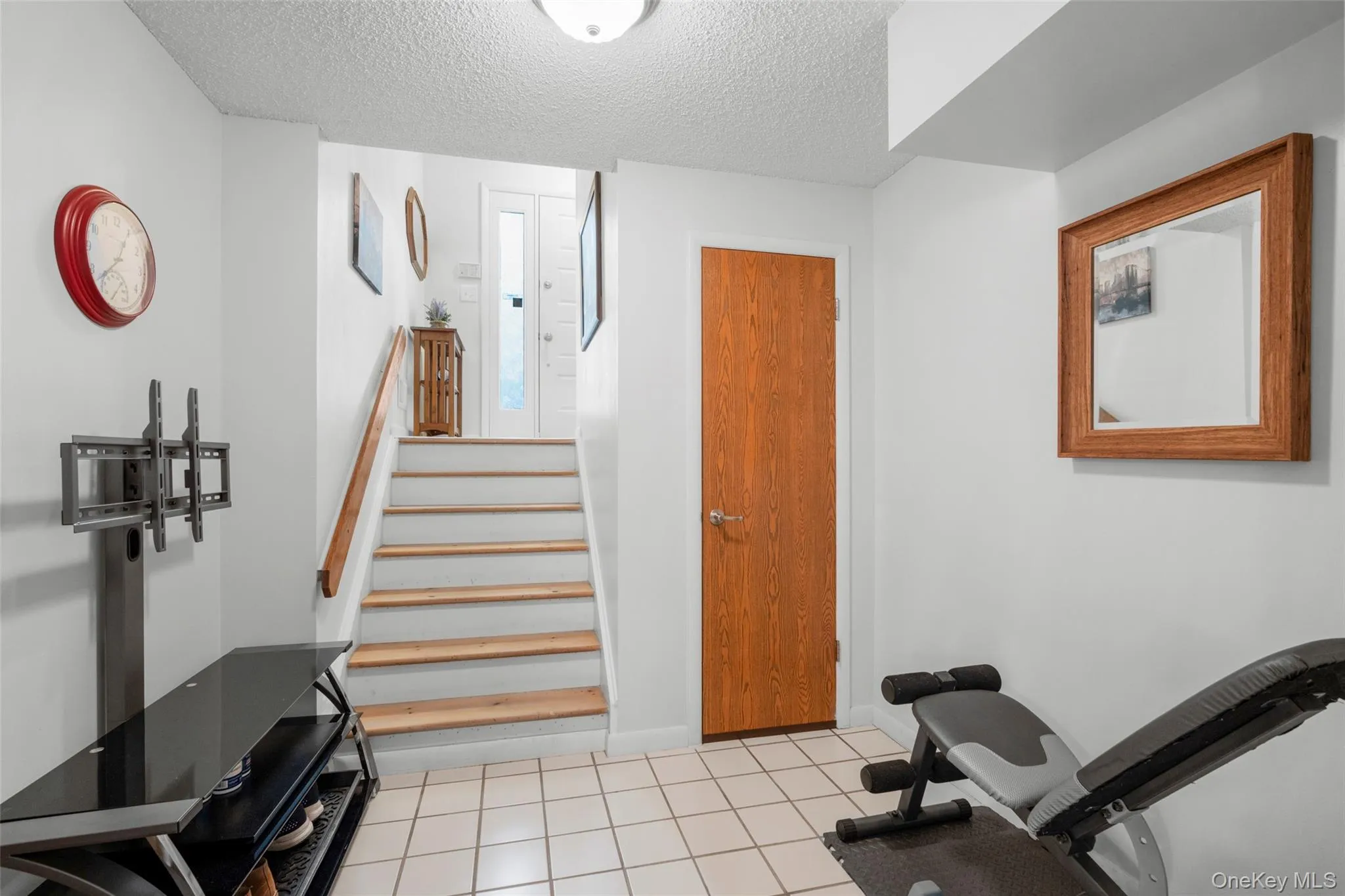 Down the steps from Foyer to Finished LL is a space currently functioning as a gym but could be ideal Mud Room as one comes in from garage on left. Door to right of stairs leads to large storage closet. Down the steps from Foyer to Finished LL is a space currently functioning as a gym but could be ideal Mud Room as one comes in from garage on left. Door to right of stairs leads to large storage closet.