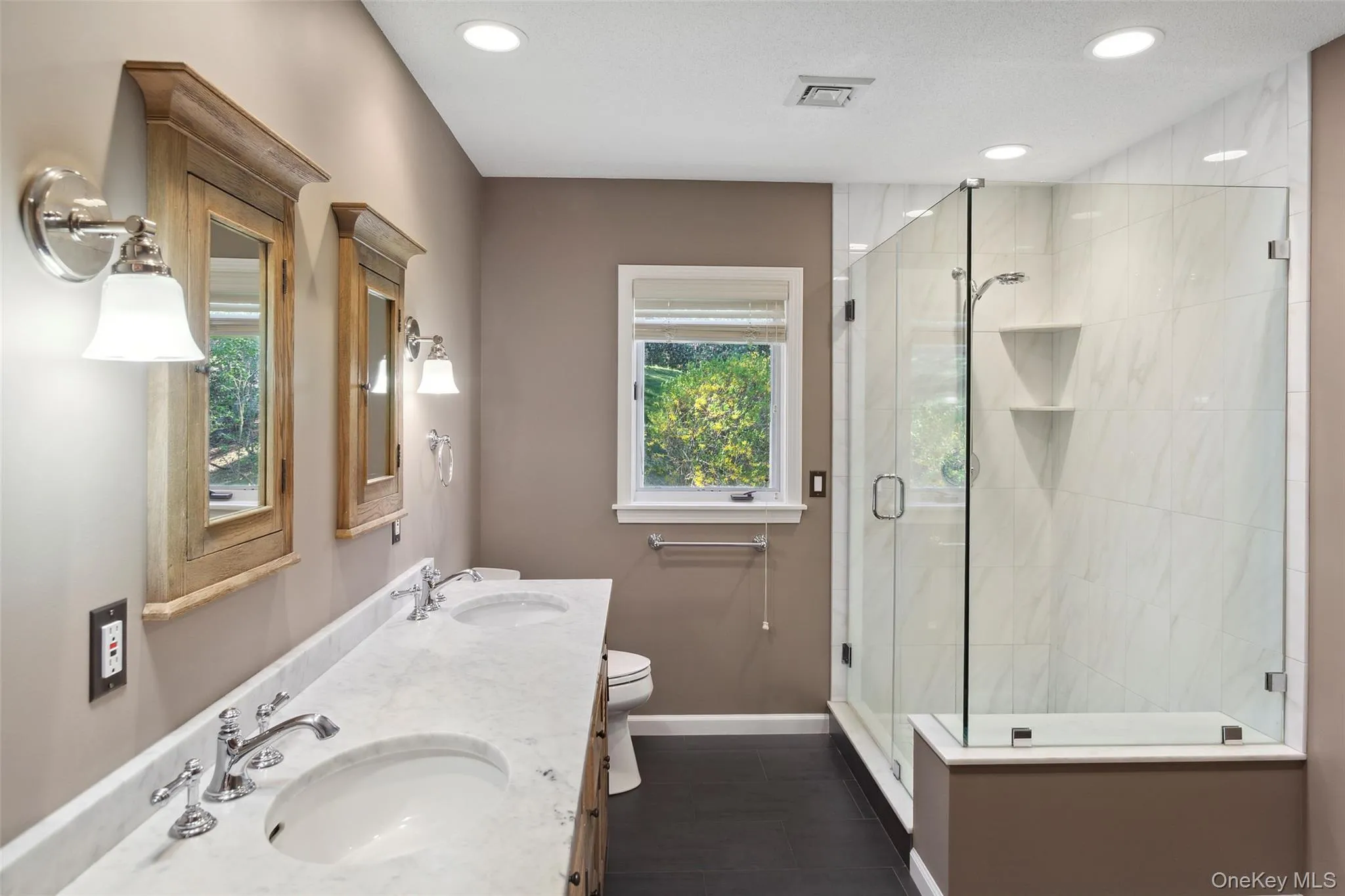 Full bath with baseboards, a sink, and a shower stall Full bath with baseboards, a sink, and a shower stall