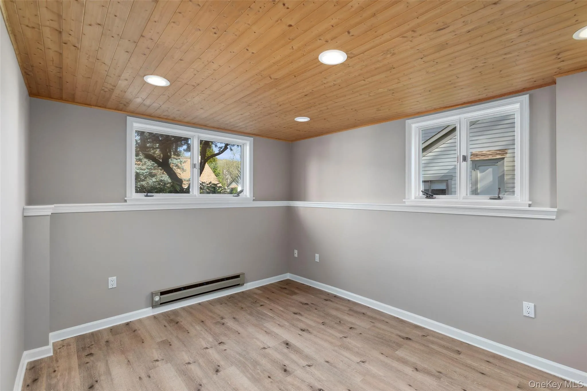 Empty room featuring wood finished floors, baseboards, recessed lighting, wooden ceiling, and a baseboard radiator Empty room featuring wood finished floors, baseboards, recessed lighting, wooden ceiling, and a baseboard radiator