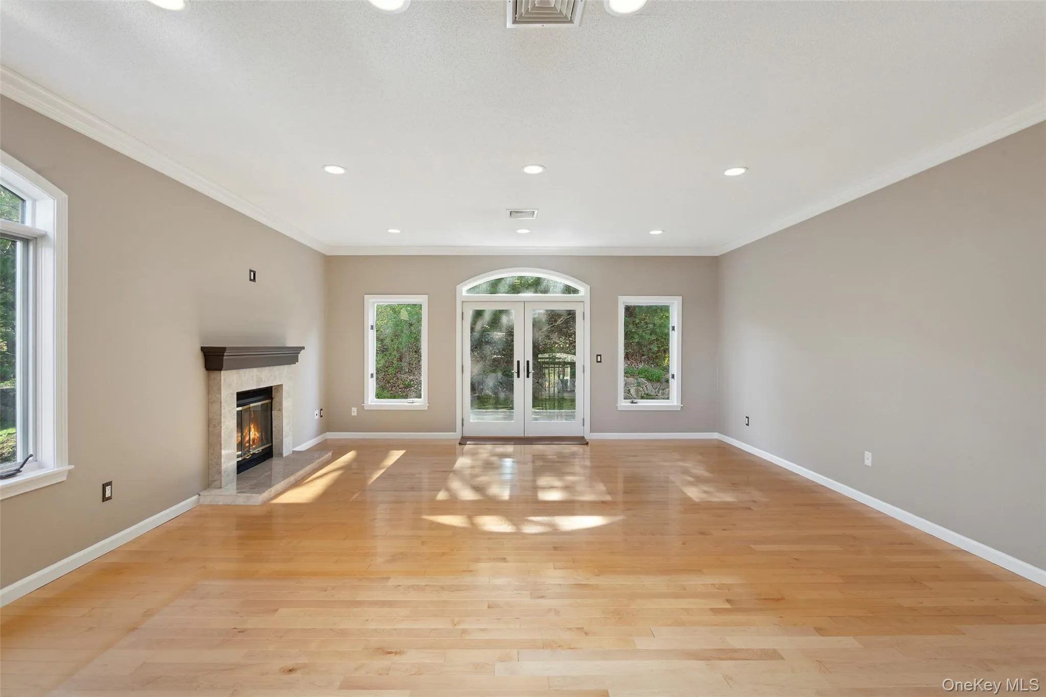 Unfurnished living room featuring a premium fireplace, recessed lighting, and plenty of natural light Unfurnished living room featuring a premium fireplace, recessed lighting, and plenty of natural light