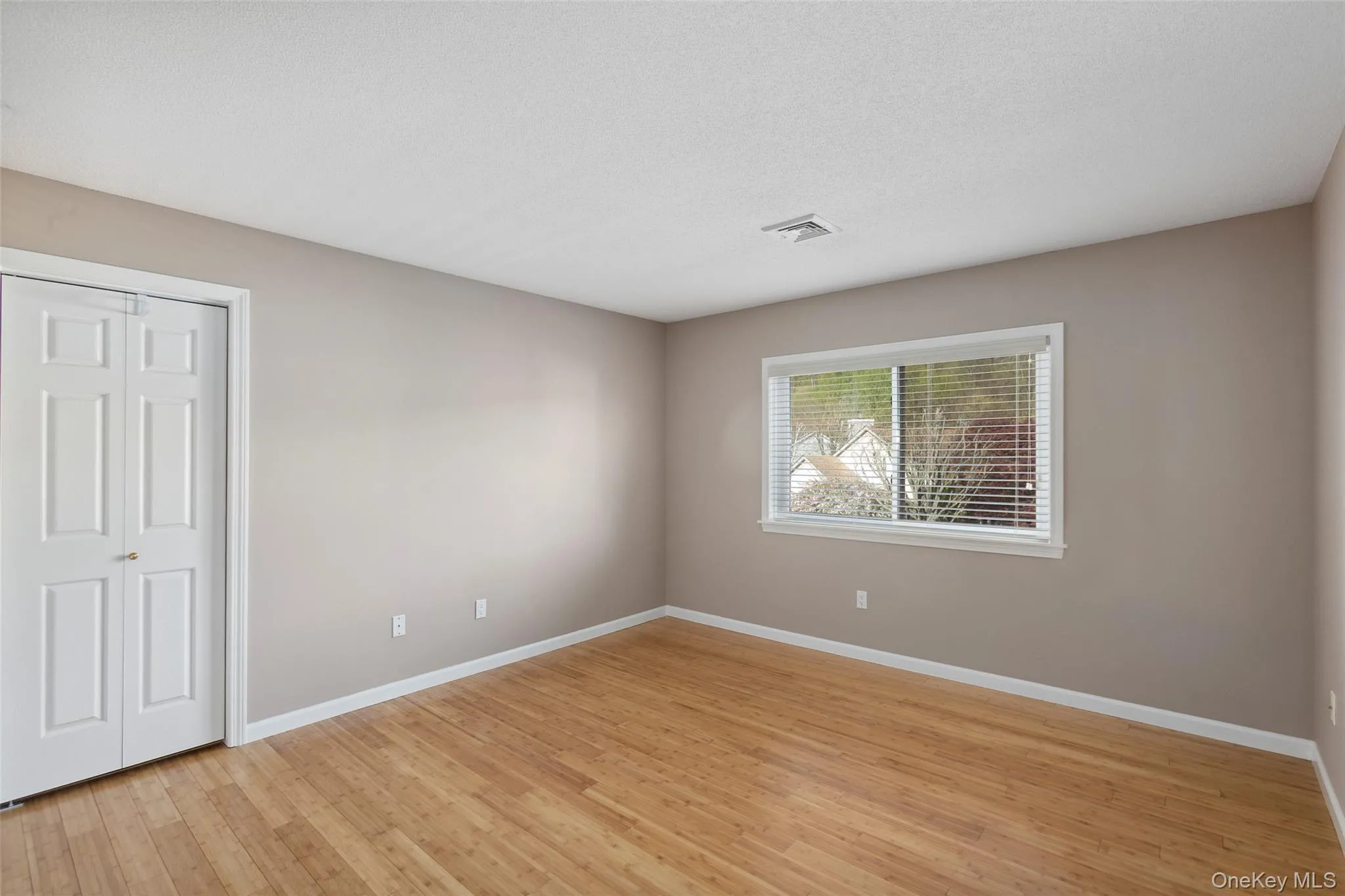 Unfurnished bedroom with baseboards, a closet, light wood finished floors, and visible vents Unfurnished bedroom with baseboards, a closet, light wood finished floors, and visible vents