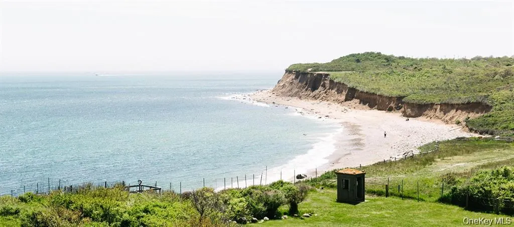 Expansive coastal property featuring a sandy beach cove, natural cliff formations, and verdant hillside Expansive coastal property featuring a sandy beach cove, natural cliff formations, and verdant hillside