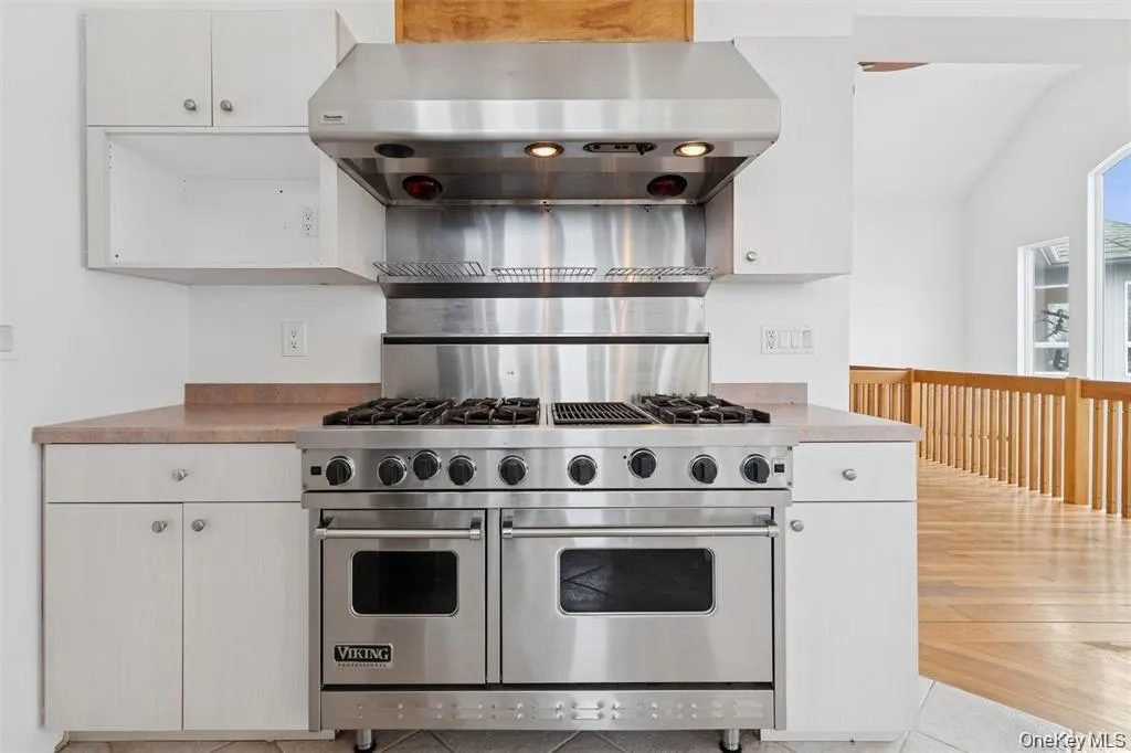 Stainless steel Viking range with double ovens and integrated griddle, complemented by a professional-grade stainless steel range hood Stainless steel Viking range with double ovens and integrated griddle, complemented by a professional-grade stainless steel range hood