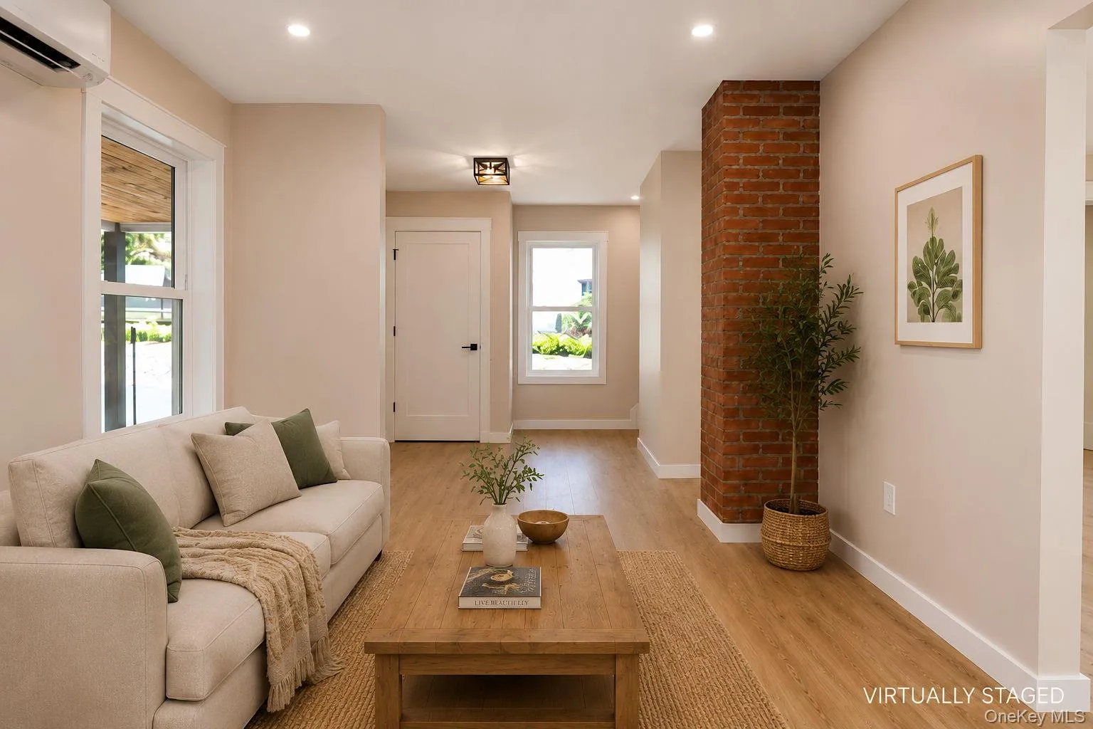 Living space featuring light wood-finish flooring and a prominent exposed brick column (enhanced) Living space featuring light wood-finish flooring and a prominent exposed brick column (enhanced)