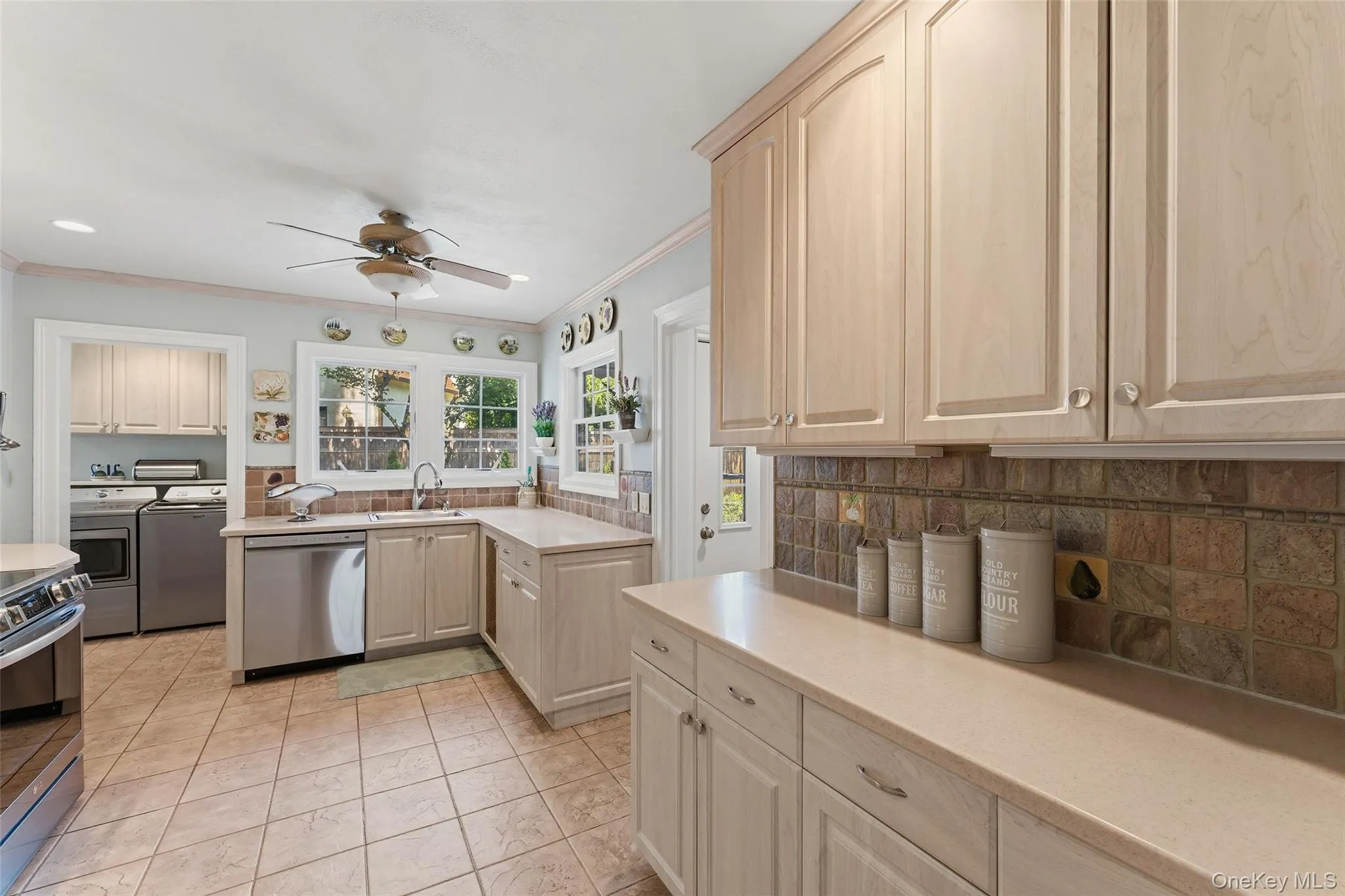 Updated Kitchen with Corian countertops, tile black splash, tile floor, stainless steel appliances and convenient main level Laundry. Access to the driveway, patios and garden. Updated Kitchen with Corian countertops, tile black splash, tile floor, stainless steel appliances and convenient main level Laundry. Access to the driveway, patios and garden.
