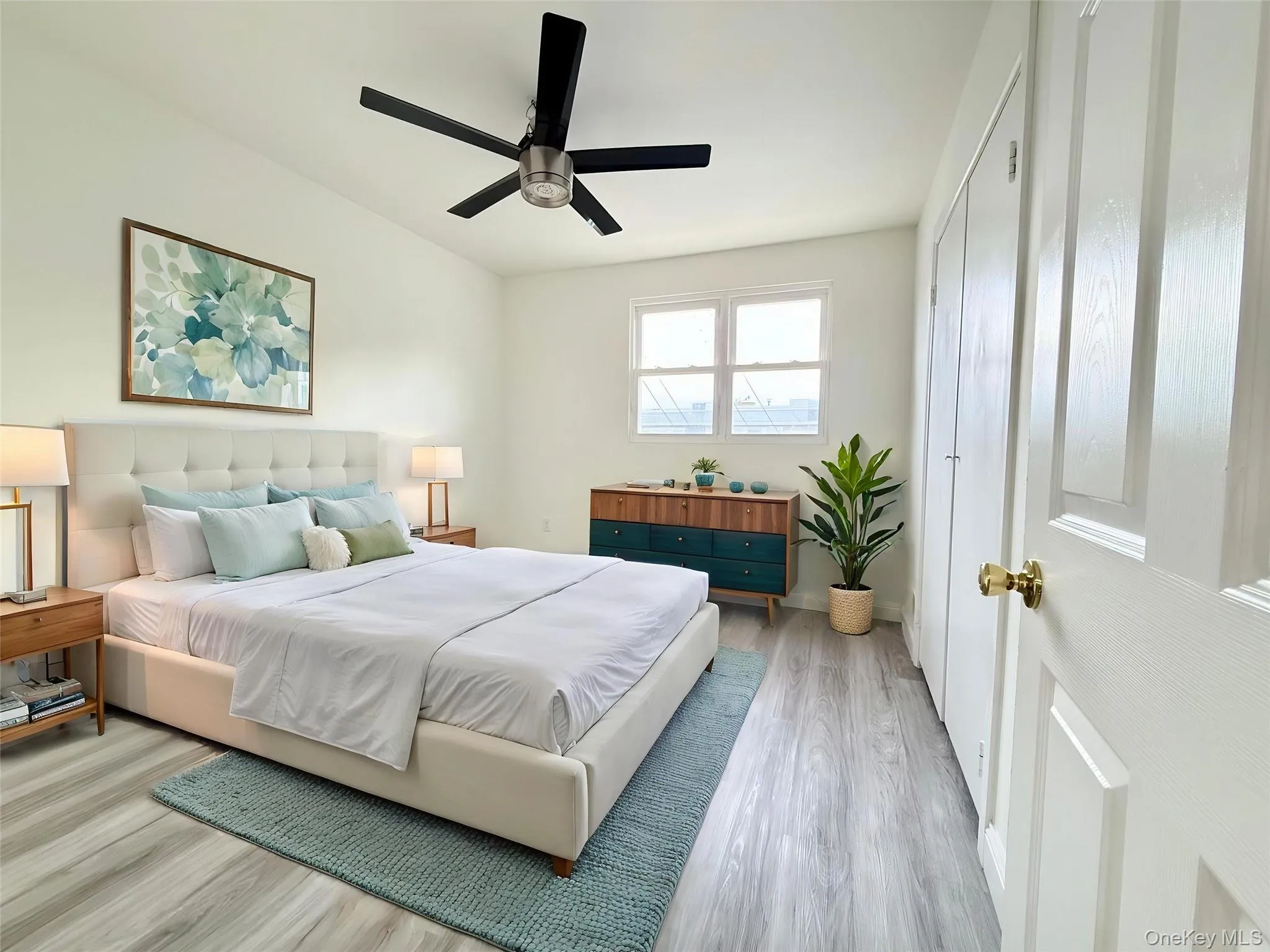 Bedroom featuring wood-finish flooring and a contemporary black ceiling fan Bedroom featuring wood-finish flooring and a contemporary black ceiling fan