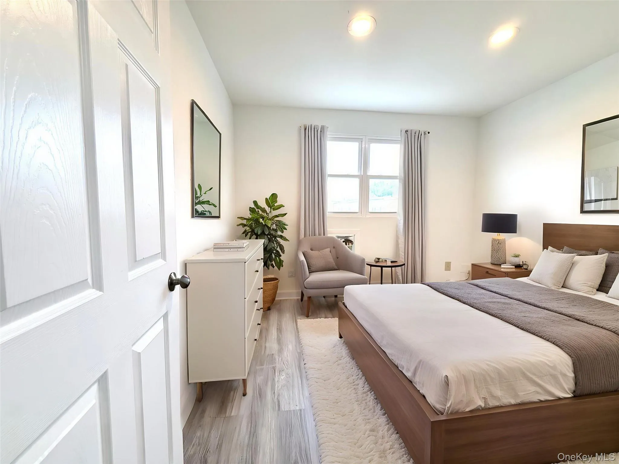 Spacious room featuring wood-finish flooring, recessed lighting, and a multi-pane window Spacious room featuring wood-finish flooring, recessed lighting, and a multi-pane window