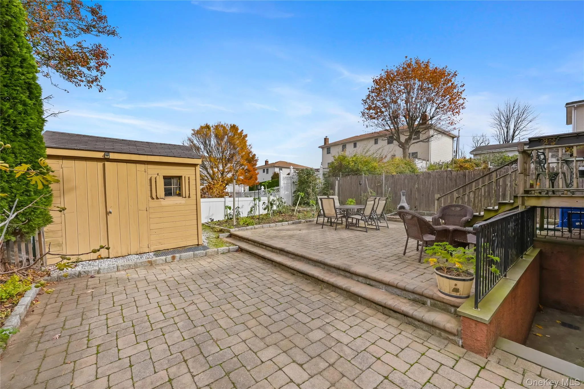 Fenced backyard with a patio area, stairway, and a storage shed Fenced backyard with a patio area, stairway, and a storage shed