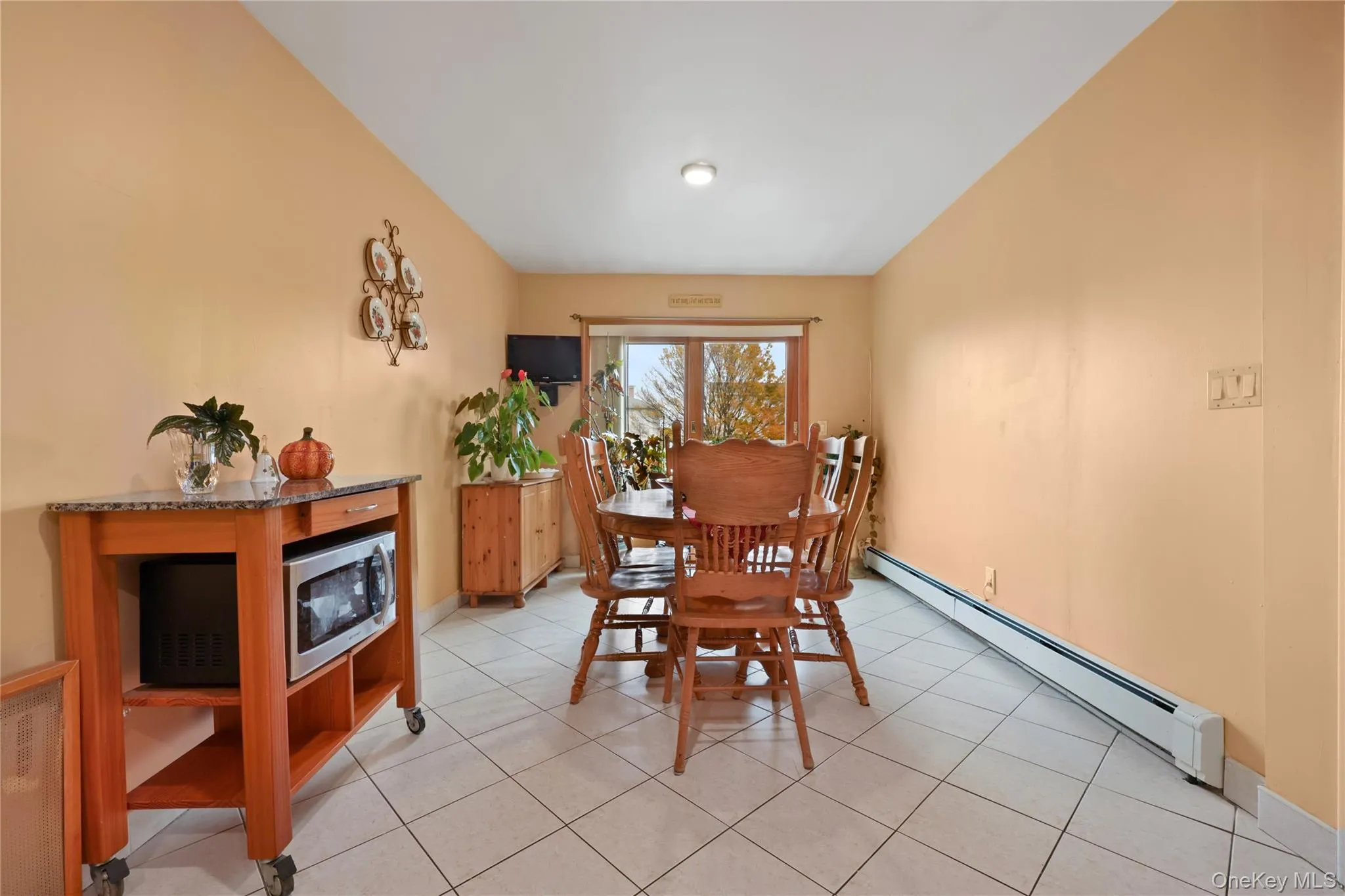 Dining room with baseboard heating and light tile patterned floors Dining room with baseboard heating and light tile patterned floors